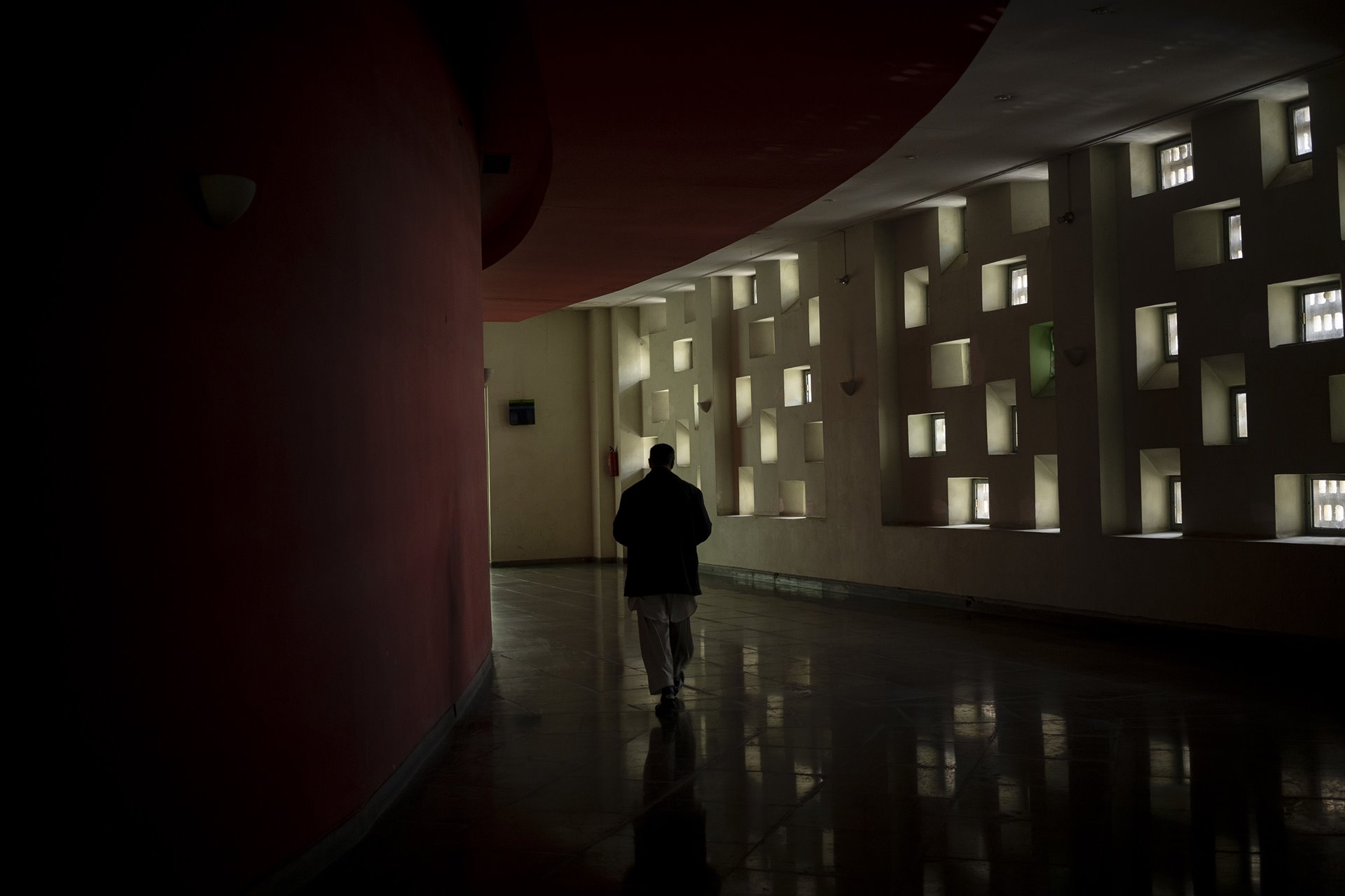 <p>A staff member walks through empty hallways at the Ariana Cinema in Kabul, Afghanistan. Even though the Taliban closed the government-owned cinema a few months earlier, the staff still arrive for work daily, in the hope they will eventually be paid.</p>
