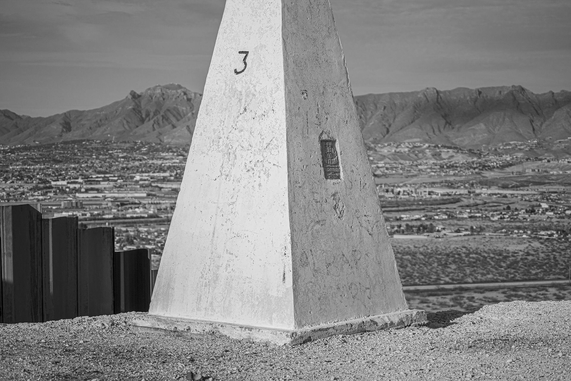 A monolith marks the international border between Mexico and the United States in Juárez, Mexico. These structures were built at the end of the 19th century, after the Mexican-American War, in which Mexico lost 55% of its land to the United States. Along the border, some of these markers stand alongside steel and concrete barriers, and in other places they can be found next to cattle fences, dirt roads, or open countryside.&nbsp;