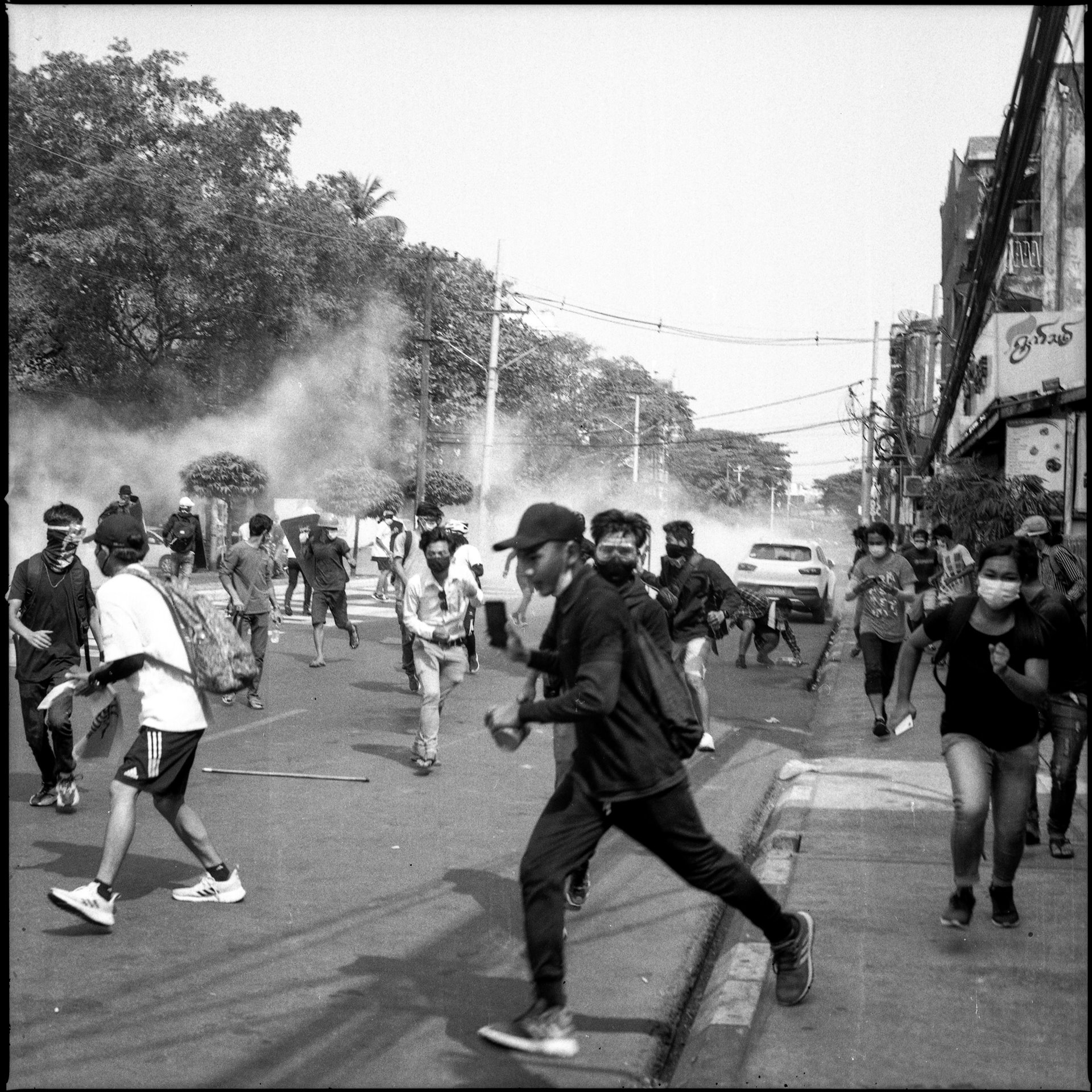 Protesters run from tear gas deployed by security forces during an anti-coup rally in Yangon, Myanmar. That day was the deadliest day of the protests up to that point, with at least 18 people killed. In addition, the police arrested two journalists and charged them with a law against defaming the military.