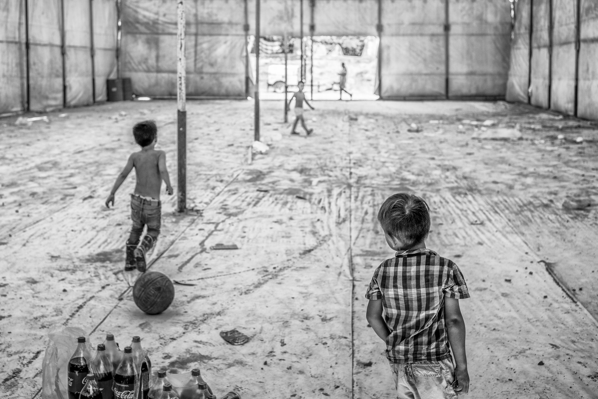 Kids play in an abandoned community dining room in Matamoros, an improvised camp set up for migrants and asylum seekers. At its peak, during the COVID-19 pandemic, this camp served 3,000 people whose applications for asylum were rejected under Title 42, a US COVID-19 prevention measure that in effect allowed deportation of migrants without reviewing asylum claims. Matamoros, Mexico.