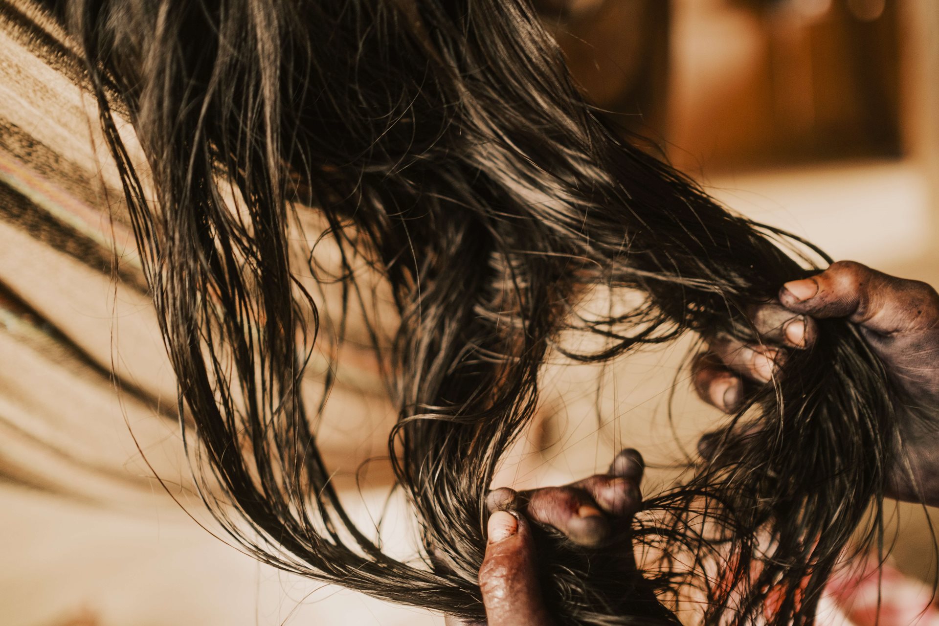 Marneli Birry (10) braids her mother Liria Cheito&#39;s hair, in Chocó, Colombia. Liria Cheito attempted suicide using her paruma, a traditional garment of her community, on 7 April 2023, after being abused by her husband.