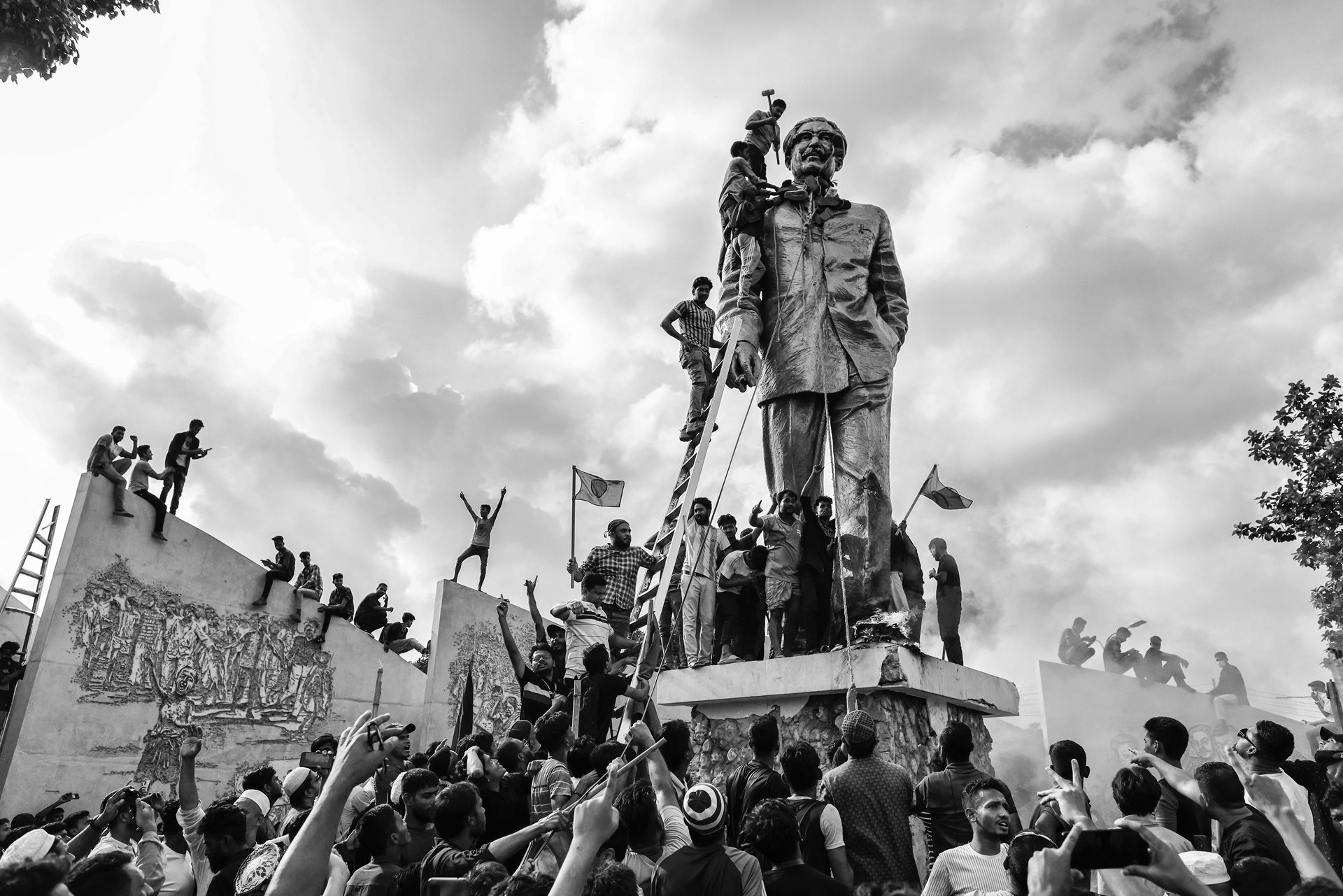 People vandalize a statue of former Bangladesh president, Sheikh Mujibur Rahman, the father of Prime Minister Sheikh Hasina, who had resigned following weeks of unrest, in Dhaka, Bangladesh.