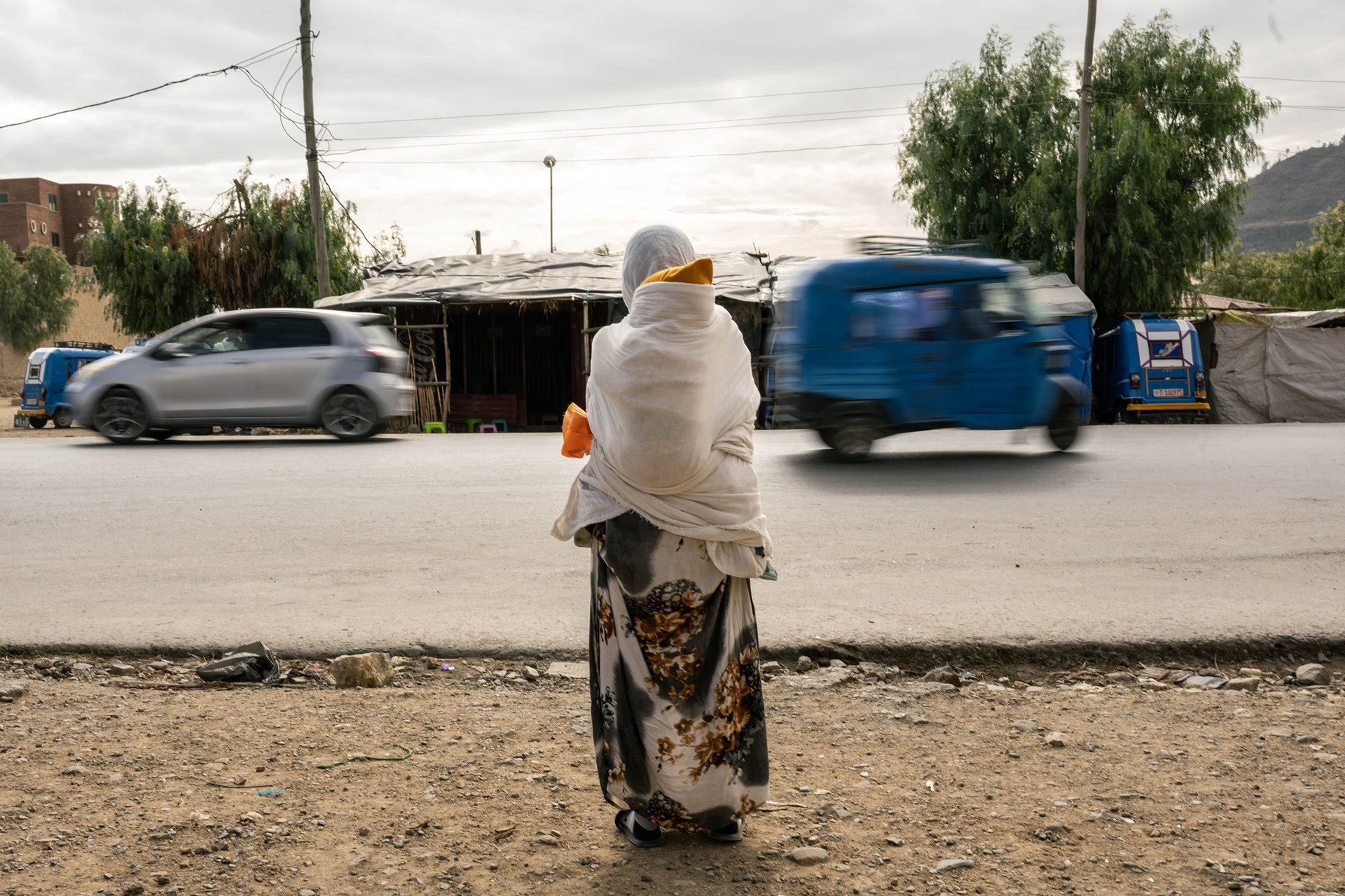 A woman waits for transport with her baby by the roadside in Mekele, Ethiopia. After being raped, she became pregnant with her now 2-year-old son. Because he was born from rape, her parents rejected her son and kept her five-year-old daughter, who was conceived with her husband. She wants to be reunited with her daughter, but worries that she will not be able to provide for her.