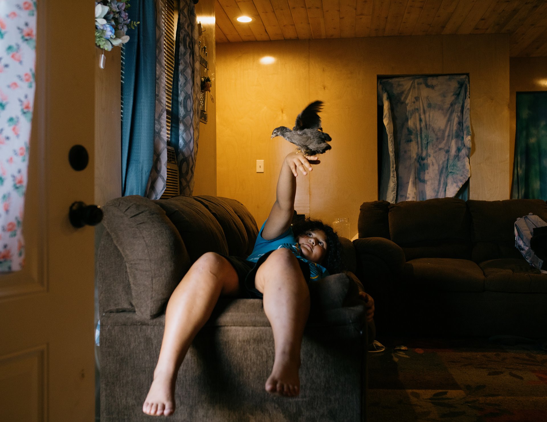 Nya Dardar, playing with one of her chickens. Along with her mother and two sisters, Nya was left homeless after Hurricane Ida. She moved in with her grandmother Patty in Pointe-aux-Chênes, in southeastern Louisiana, United States, where she now resides. Her family did not meet the criteria for resettlement in Gray.&nbsp;