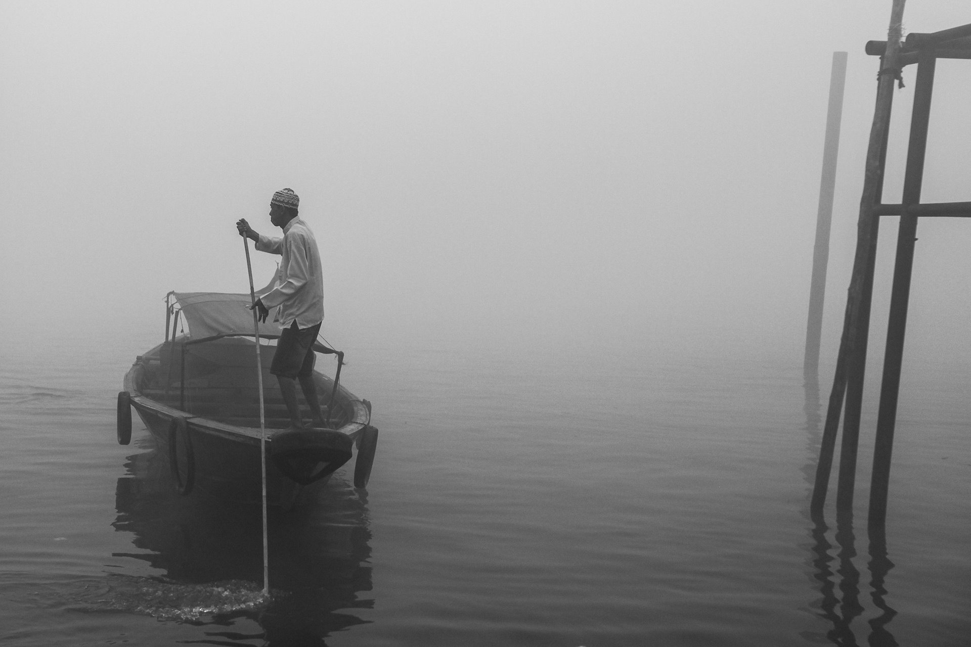 A man propels a boat along the Musi River, in South Sumatra, Indonesia, while thick smog from forest fires blankets the regional capital, Palembang.