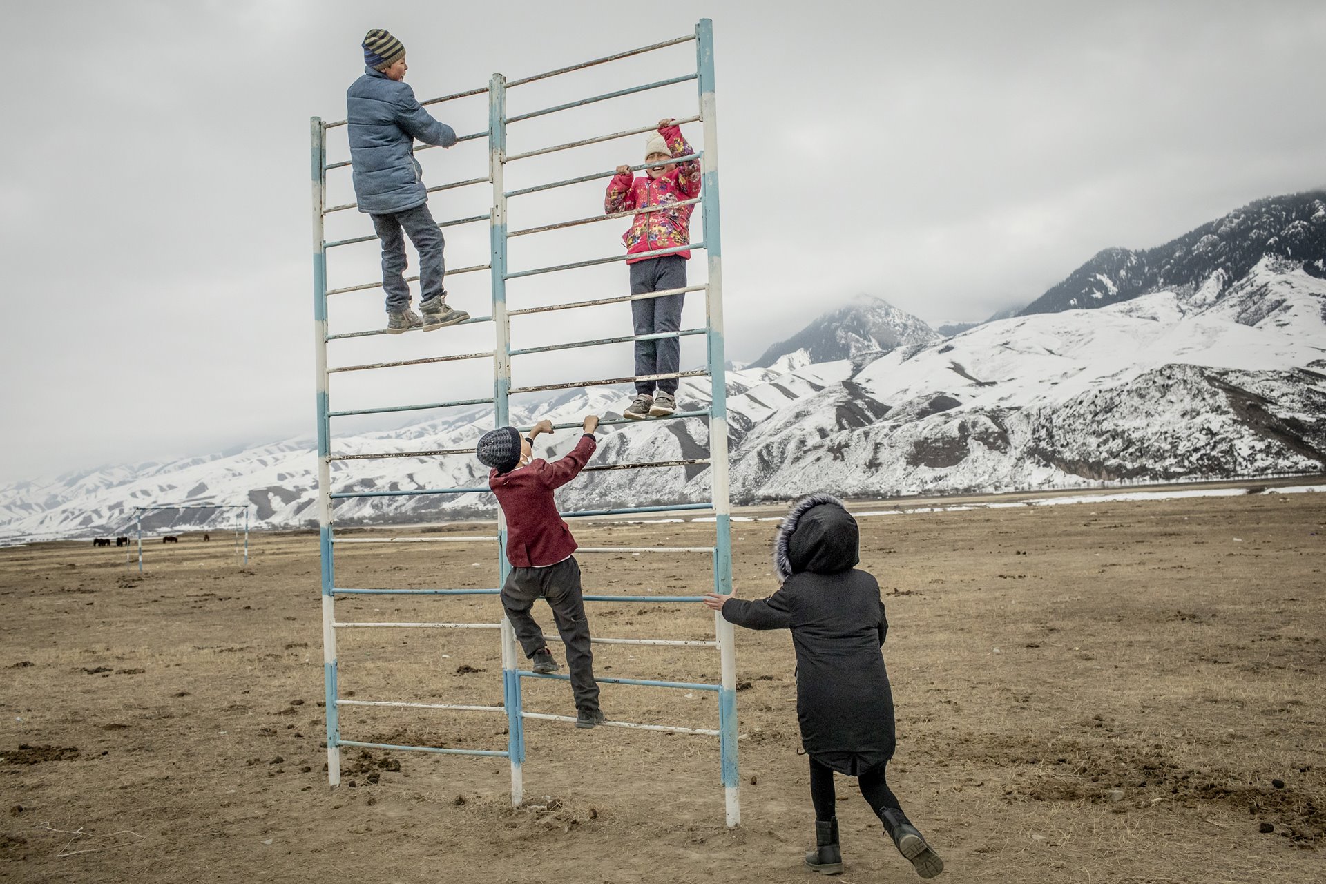Children climb in an outdoor playground near the Naryn River, in Ak-Kyya, Kyrgyzstan. The Naryn, which feeds into the Syr Darya River, supplies hydroelectric power to the region.