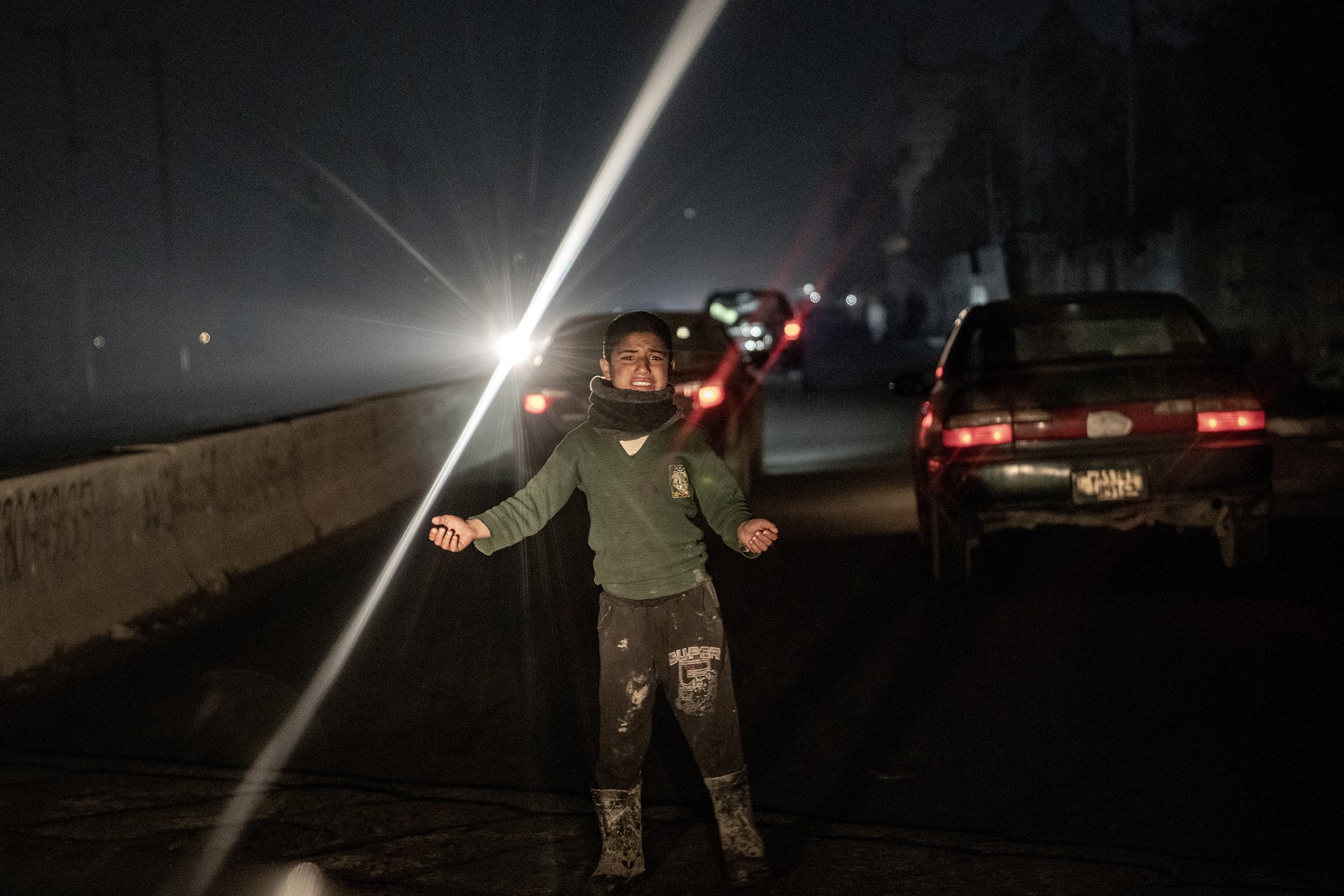 An internally displaced Afghan boy begs on city streets at night in Kabul, Afghanistan.&nbsp;