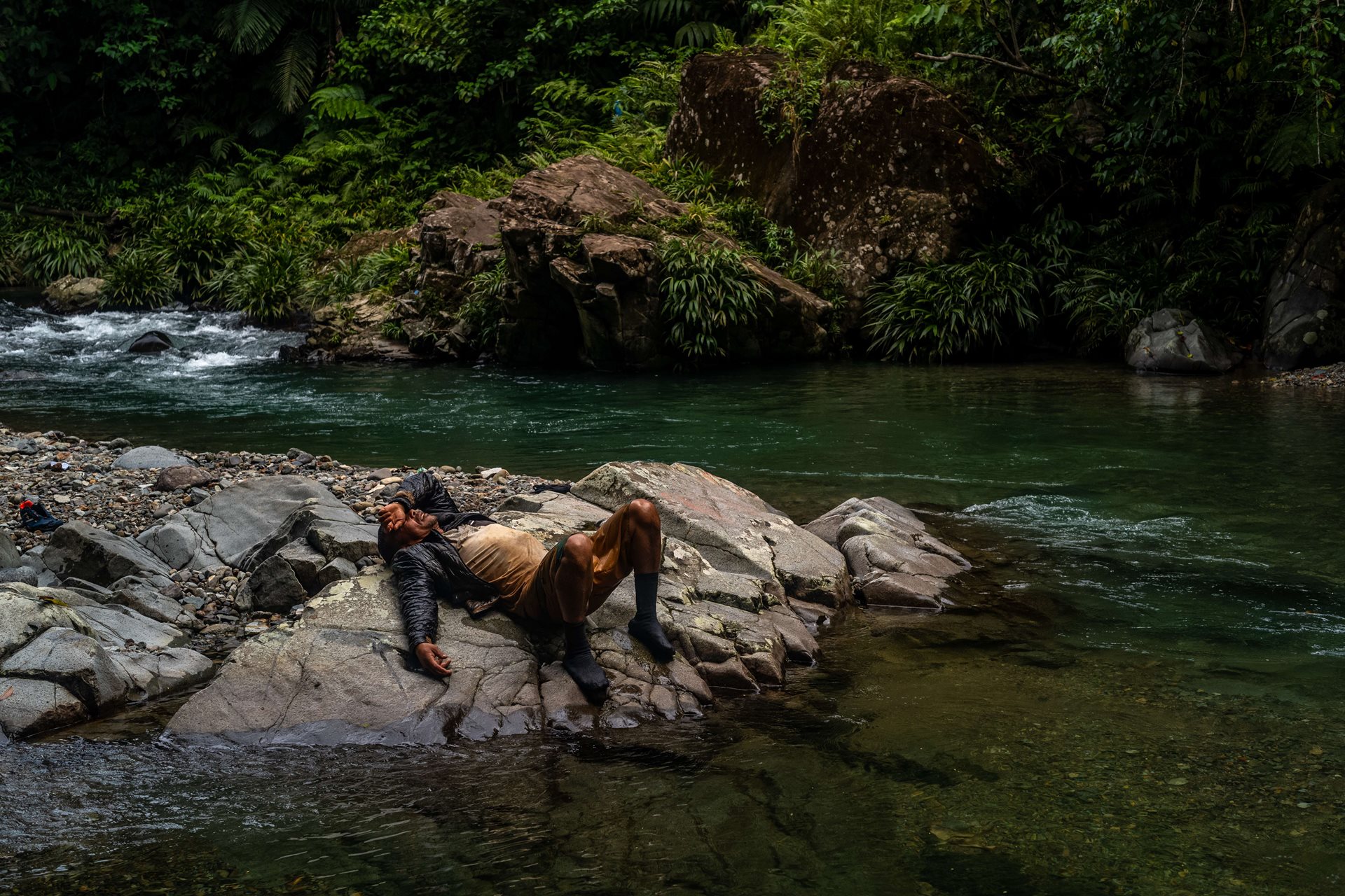 Hamlet Ortega breaks down in exhaustion beside the Tacartí River, in Panama, on his journey through the gap. What little food he had for the journey he saved for his three daughters. After the death of his wife in Venezuela from breast cancer, Hamlet migrated to Peru with his young daughters. There, he could only find work collecting garbage. One day, his daughters said they had seen the Darién on social media and convinced him to take that route to migrate once more.