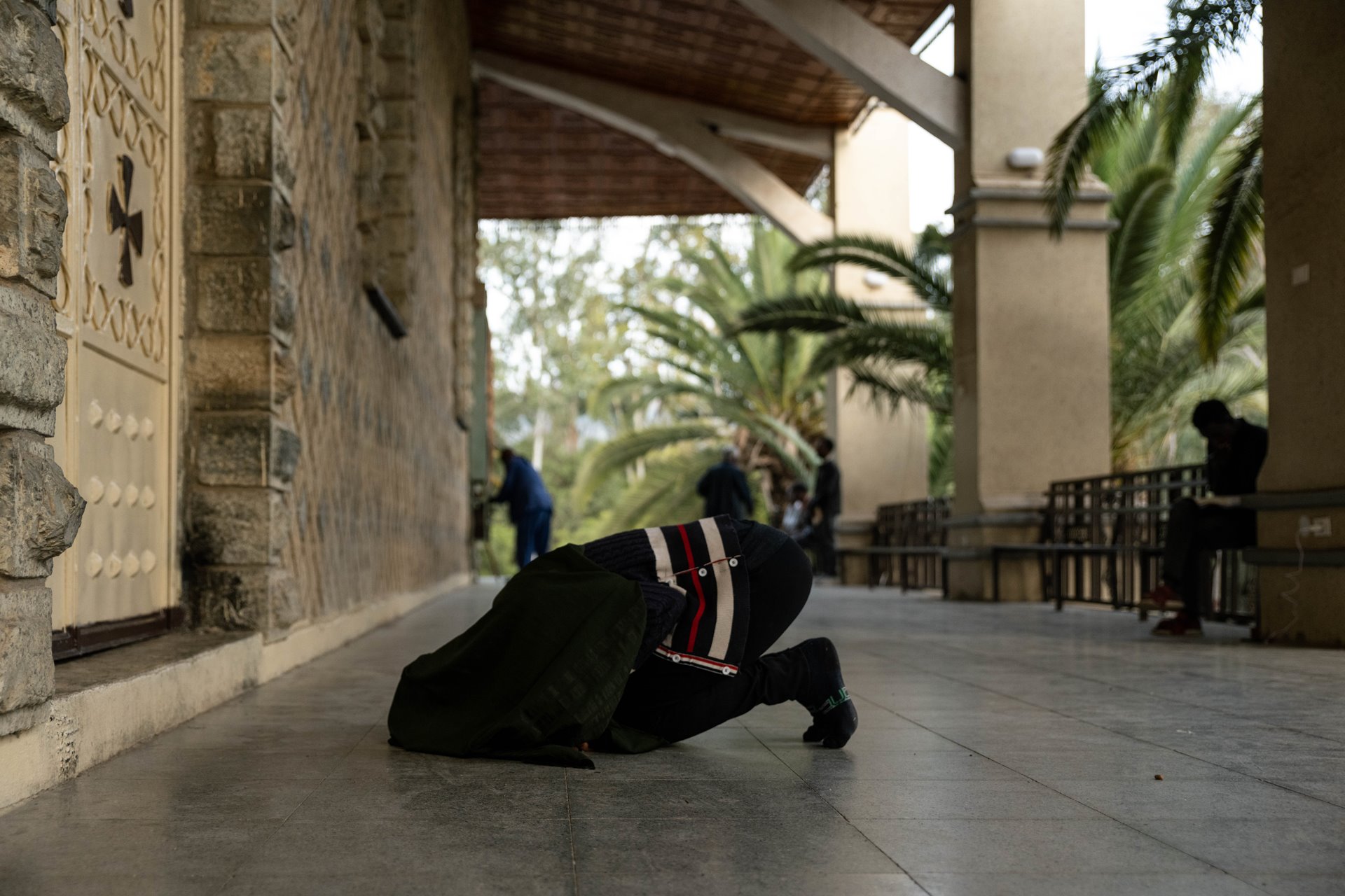 Shila (32) performs her evening prayer in front of an Orthodox Christian church in Mekele, Ethiopia. The population of Tigray is over 90 percent Orthodox Christian.