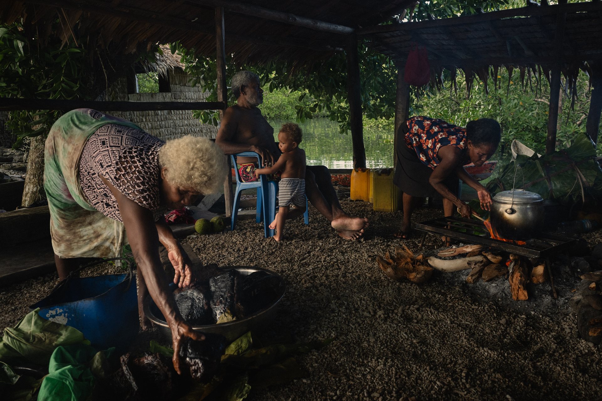 Smoke rises as families cook dolphin meat gifted by neighbors. After an unsuccessful season, Fanalei&rsquo;s residents rely on customary sharing across the Surodo Lagoon. Fanalei Island, South Malaita, Solomon Islands.