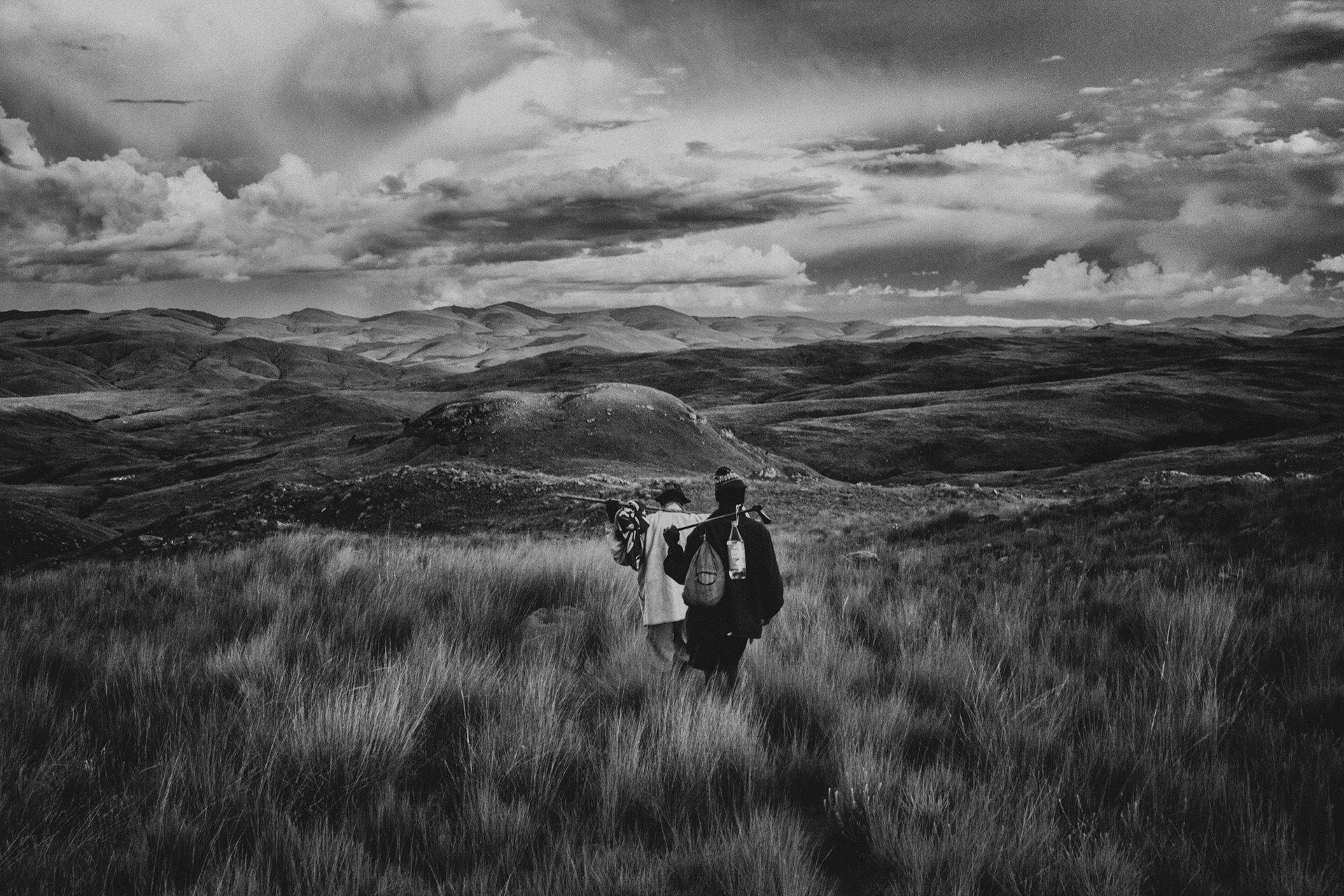 Two people cross grassland in the Andriry Mountains, an isolated area of Madagascar accessible only on foot and with neither phone network coverage nor electricity.