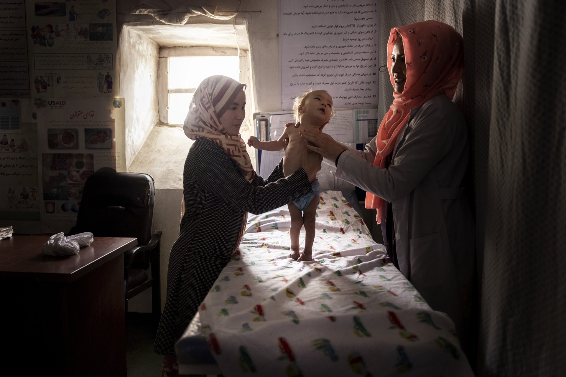 Hojatullah (11 months old) is examined at a small clinic in Alibeg, near Bamiyan, Afghanistan. Although very young, he is already suffering from severe malnutrition, a common problem in this village where most survive on a daily diet of white bread and tea.