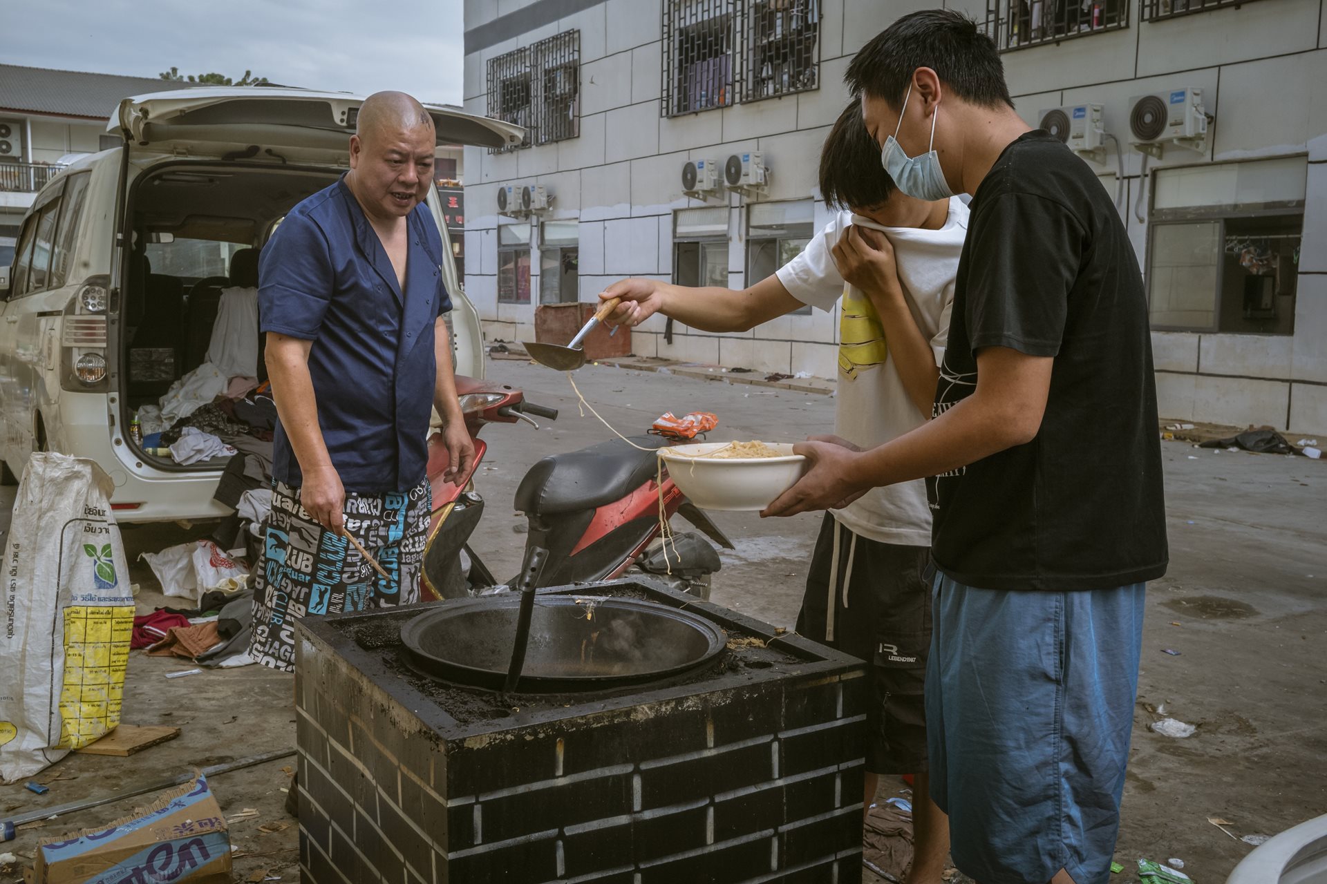 Scam center workers cook food outside a dormitory. Opened in 2024, Shunda Park employed 3,500 people from nearly 30 nations. While some were experienced scammers, many were victims of human trafficking, lured to Myanmar by ads for high-paying tech jobs in Thailand. Min Let Pan, Myanmar