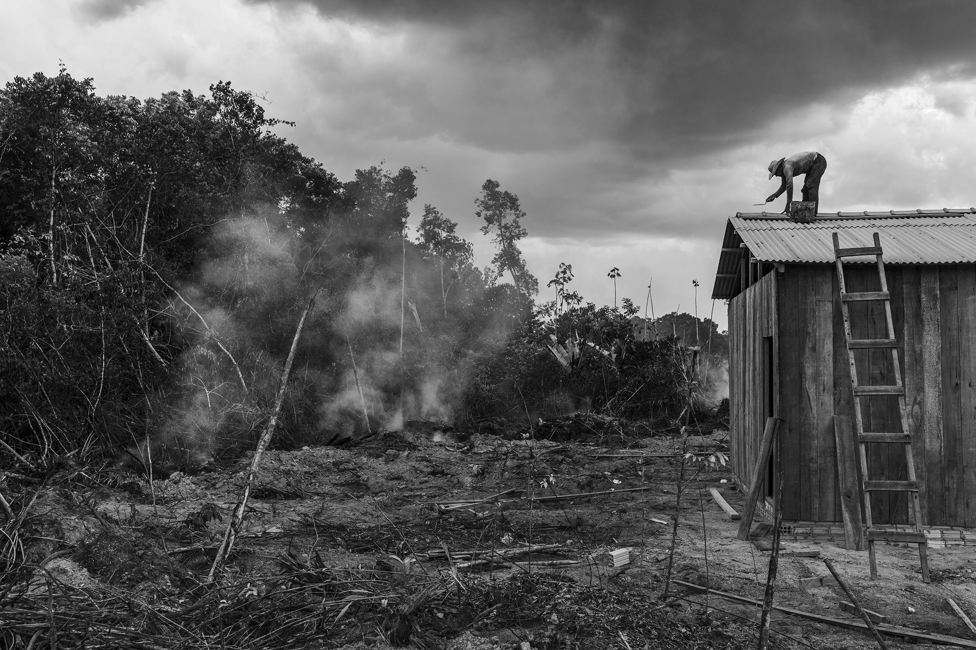 Settlers build a house on a newly deforested plot of land alongside the BR-319 road near the village of Realidade in Humaitá in the Brazilian Amazon. The road, which connects the cities of Manaus and Porto Velho, was delivered asphalted in 1976, but degraded due to lack of maintenance and was abandoned as impassable in 1988. Repaving the B-319 would open space in the heart of the Amazon to commercial exploitation.