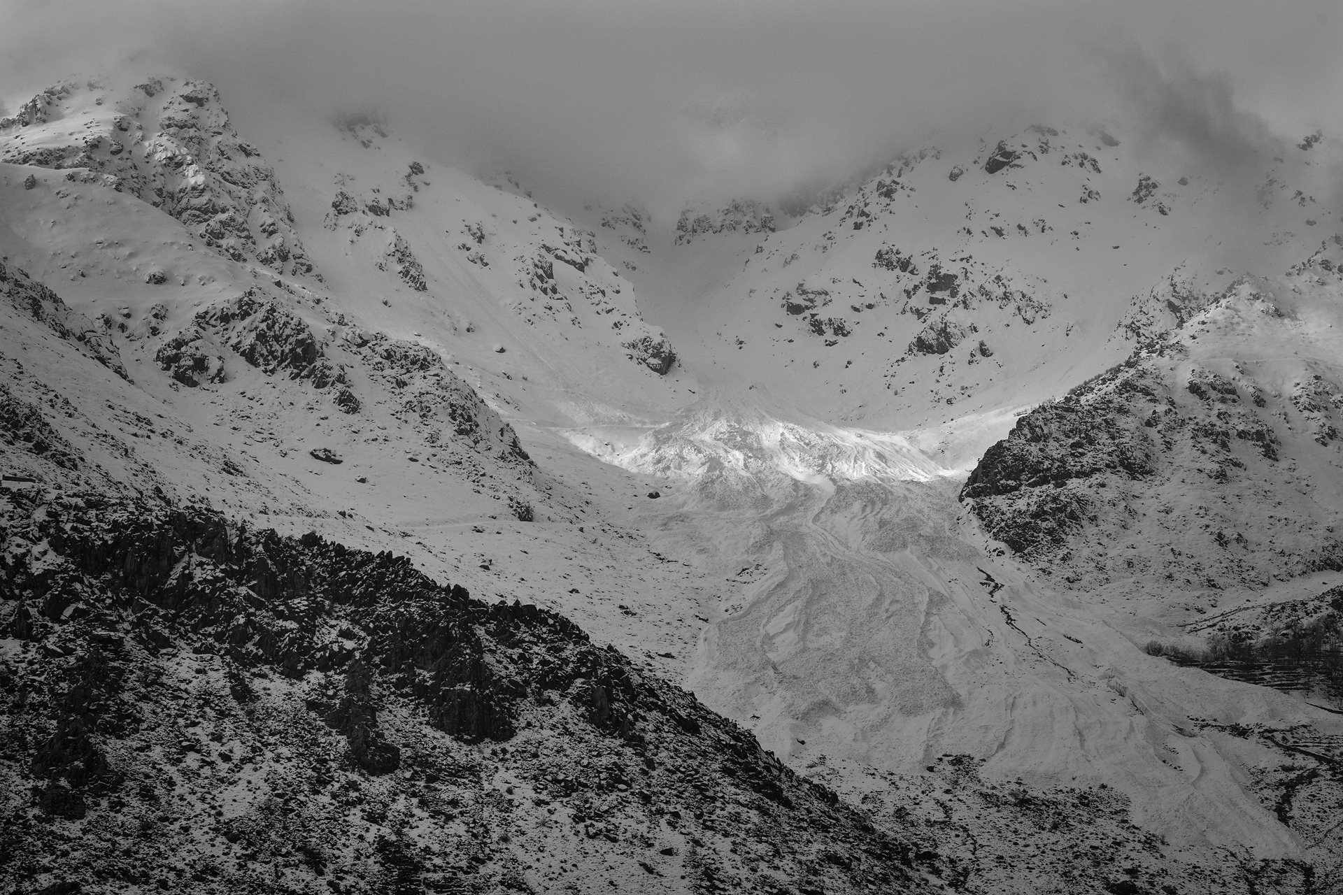 A ray of sunlight touches an avalanche that blankets a kolbari route, in Kurdistan, Iran. Each year, avalanches and extreme cold are among the leading causes of death for kolbars, yet they remain resilient.