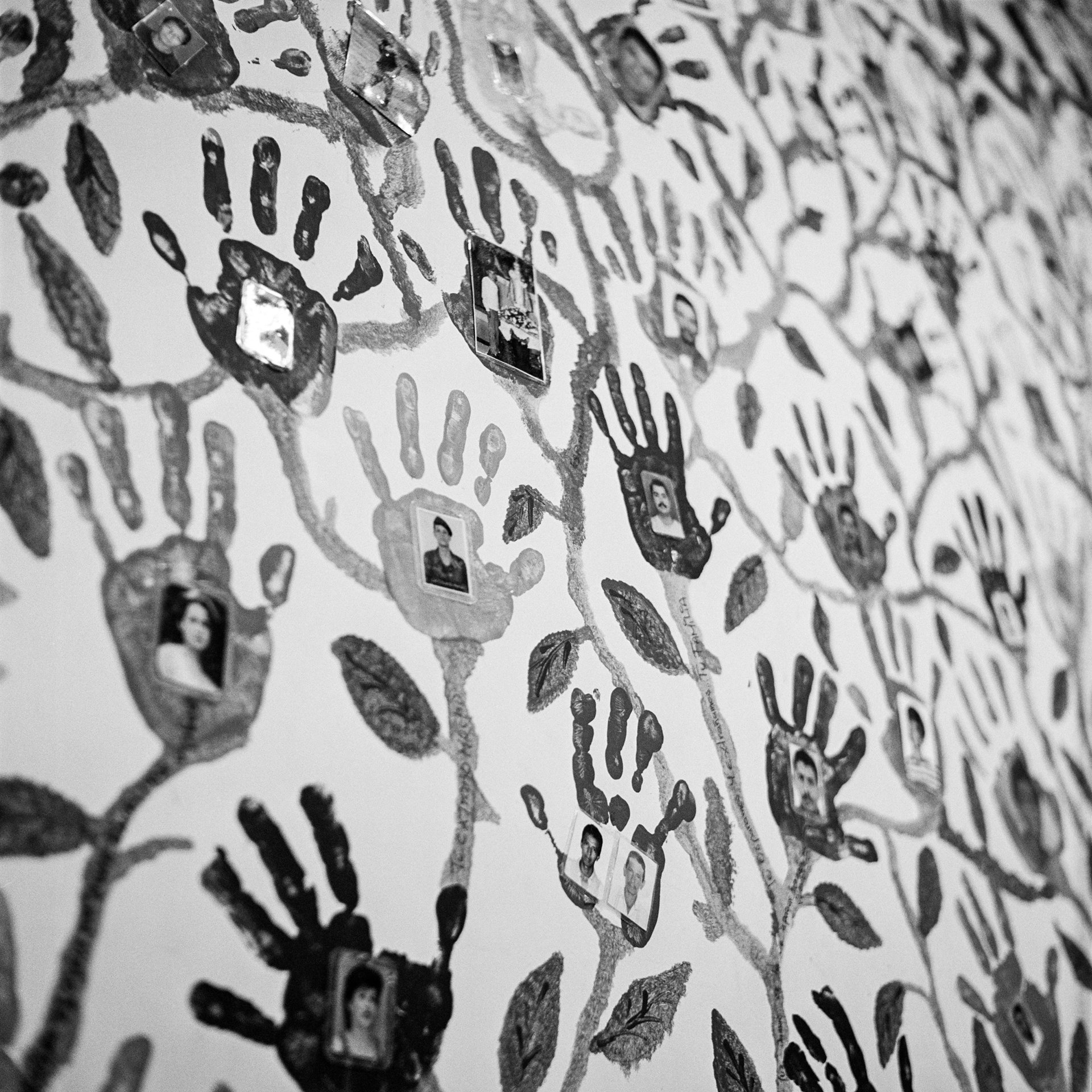 Handprints of relatives of disappeared people and photographs of the missing adorn a wall of the headquarters of the Madres de la Candelaria, an organization created in Medellín, Colombia, in March 1999, in response to the many forced disappearances taking place in the country. Every Friday, female relatives of the disappeared gather to commemorate them and protest their disappearances.