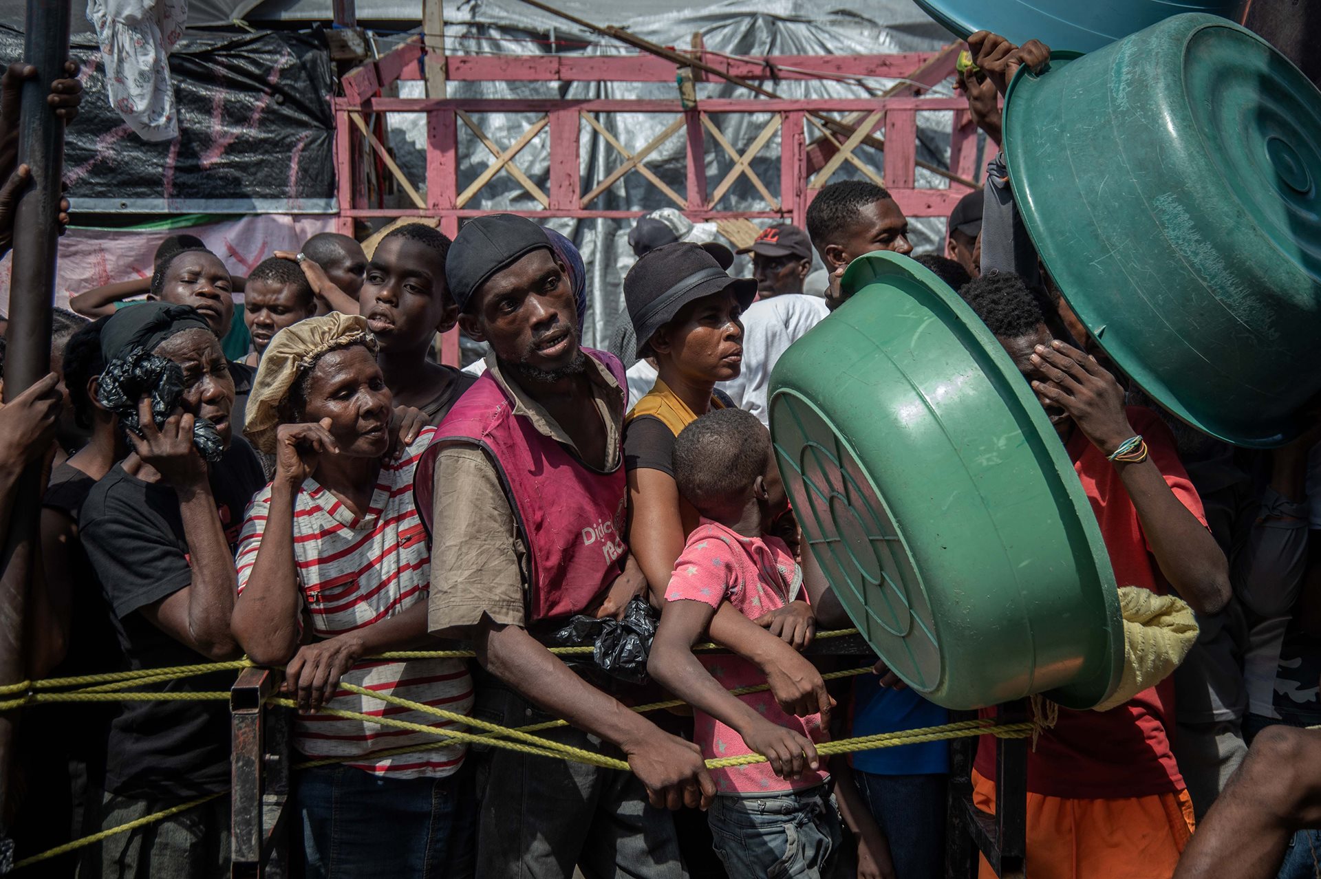 People displaced by gang violence wait for food to be distributed at a displaced persons camp at the Lycée Marie Jeanne in Port-au-Prince, Haiti.