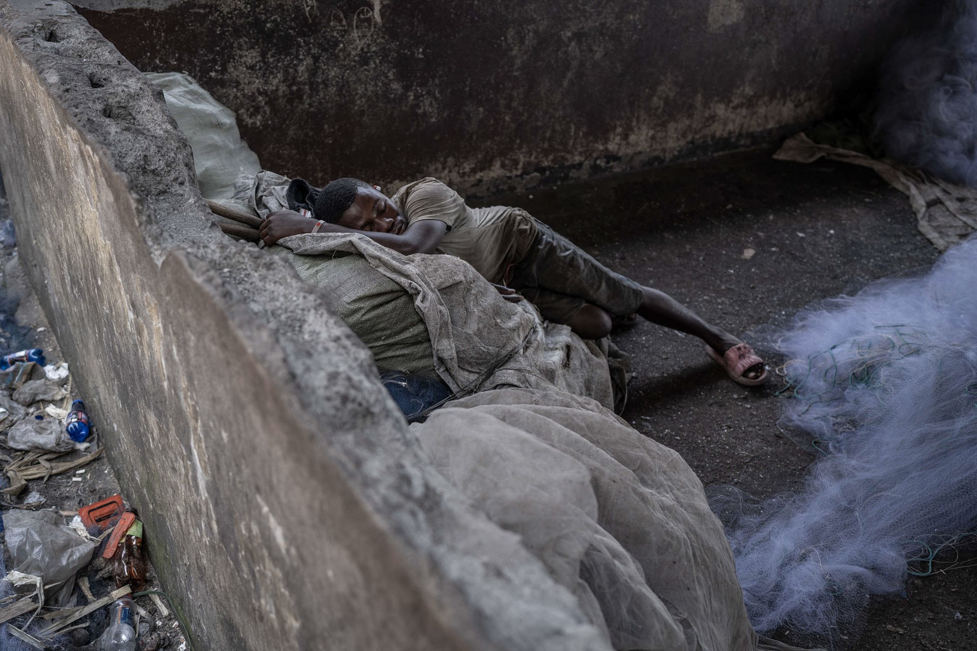 A fisherman sleeping on his nets at the fishery, in Goma, DRC.