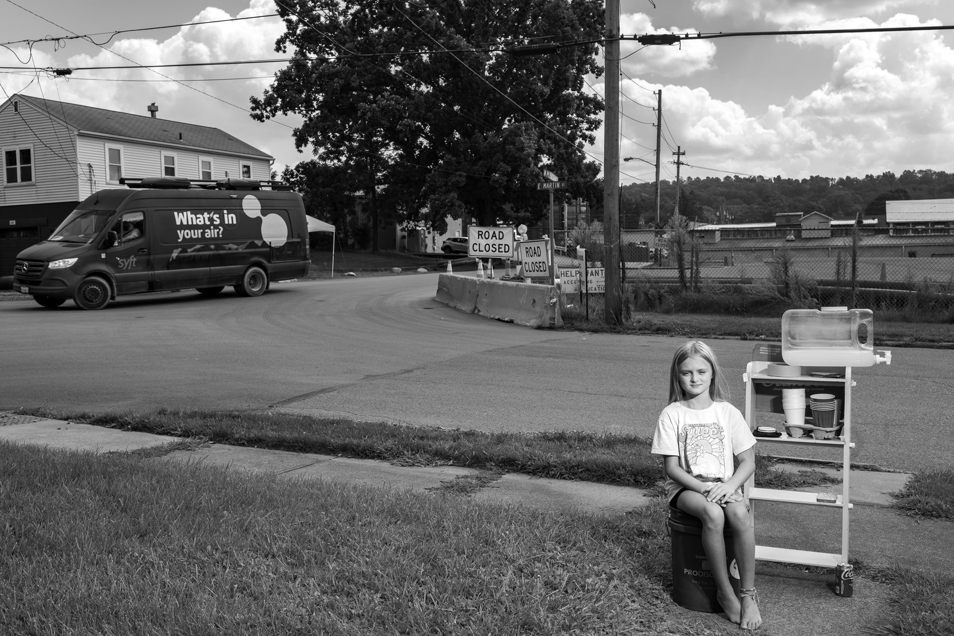 LaBrea Letson (8) sells lemonade made with bottled water outside her grandmother&rsquo;s home near the derailment site, in East Palestine, Ohio, United States. A van passing by tests the air for hazardous chemicals.&nbsp;