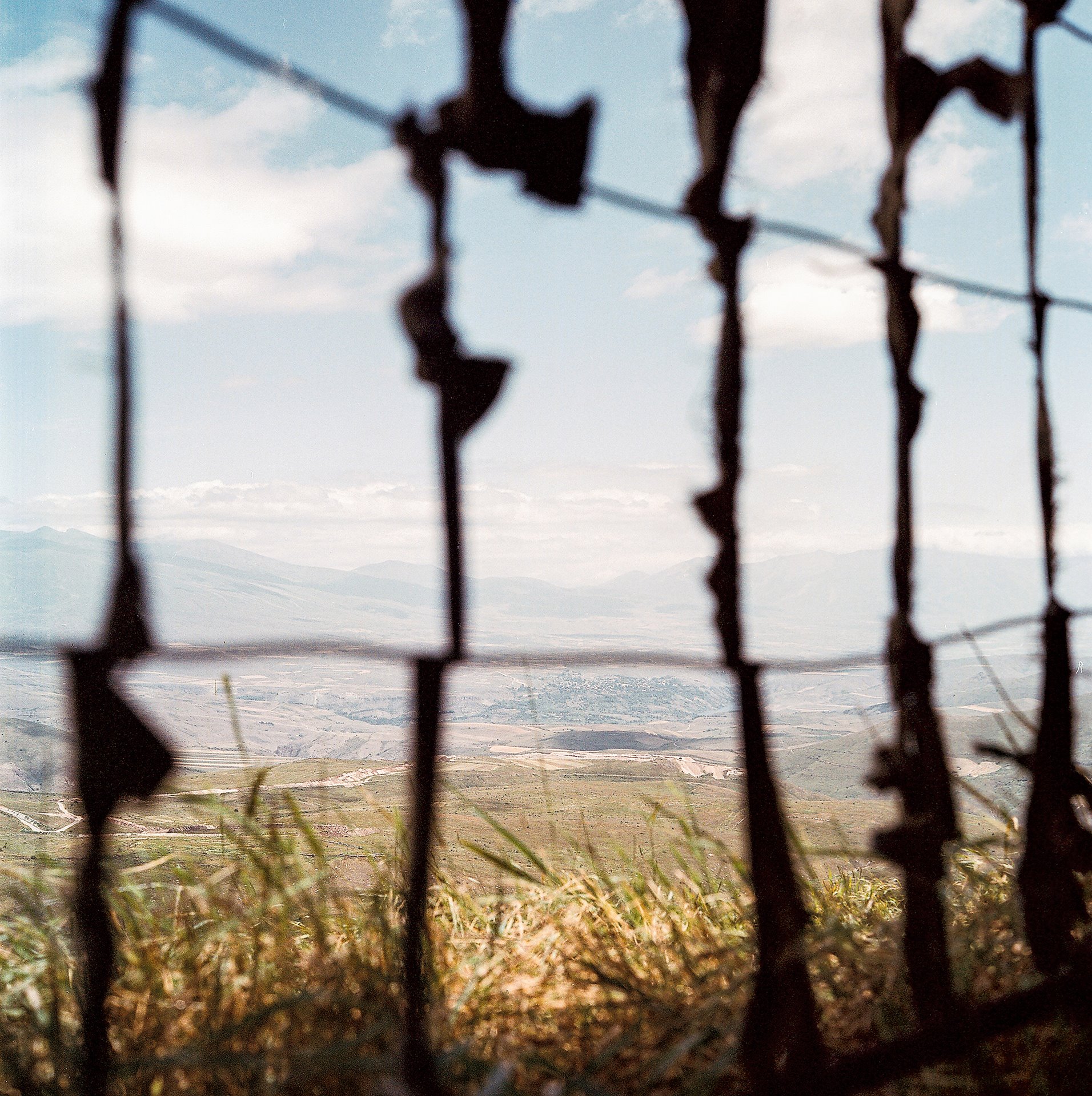 A view from between sniper positions overlooking a land littered with mines at the militarized border of Armenia and Azerbaijan, Nakhchivan, Azerbaijan. The Satyrus effendi butterfly, named after Rustam Effendi, the photographer&rsquo;s father, flies across this border, traversing the Zangezur mountain ridge.