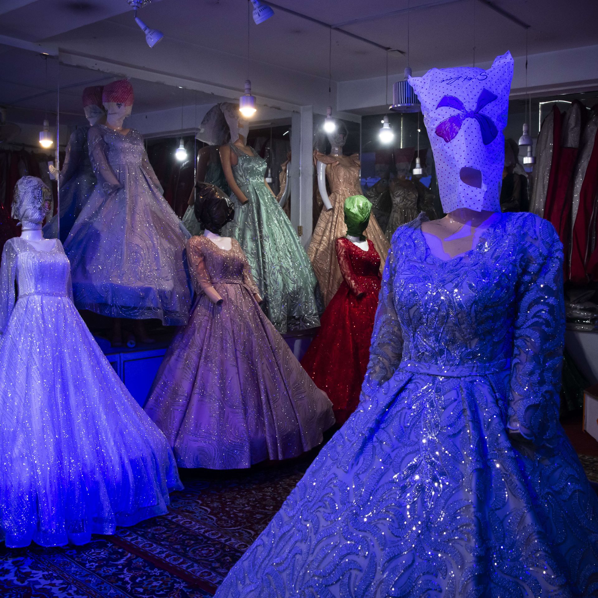 Plastic bags cover the heads of mannequins wearing wedding dresses, in Kabul, Afghanistan. Women&#39;s faces on advertisements, posters, and other public displays in Afghanistan are also erased or covered, in response to Taliban restrictions. At first, the Taliban required all mannequin heads to be removed, but eventually allowed the figures to remain intact if their faces were covered.