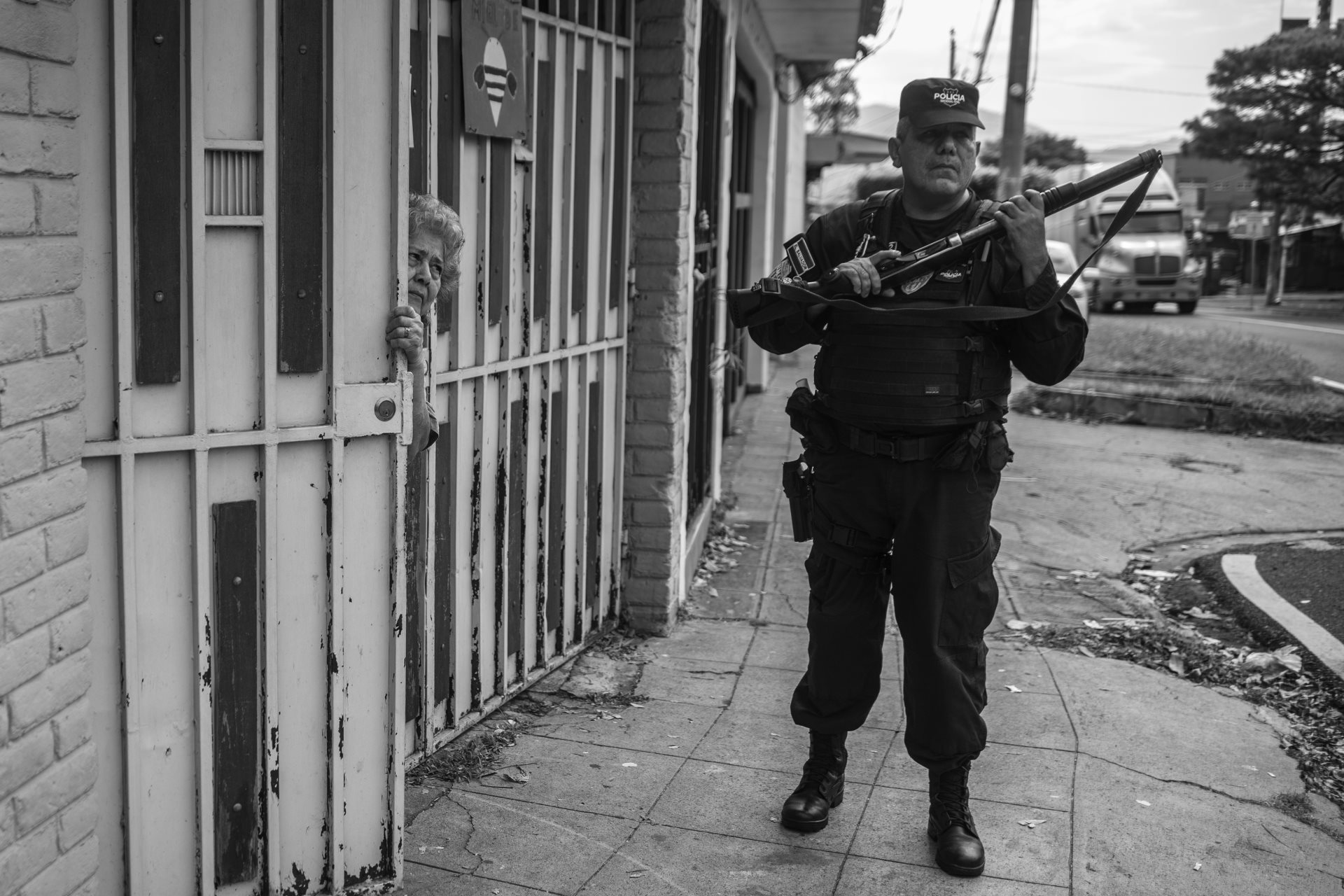 A police officer, weapon loaded, stands guard at a demonstration held by relatives of victims of the &ldquo;state of emergency.&rdquo; Human rights organizations accuse the police of acting as judges and arresting thousands of innocent people. Investigative journalists have reported that in certain cases, police arrested people based on nervous behavior alone. San Salvador, El Salvador.