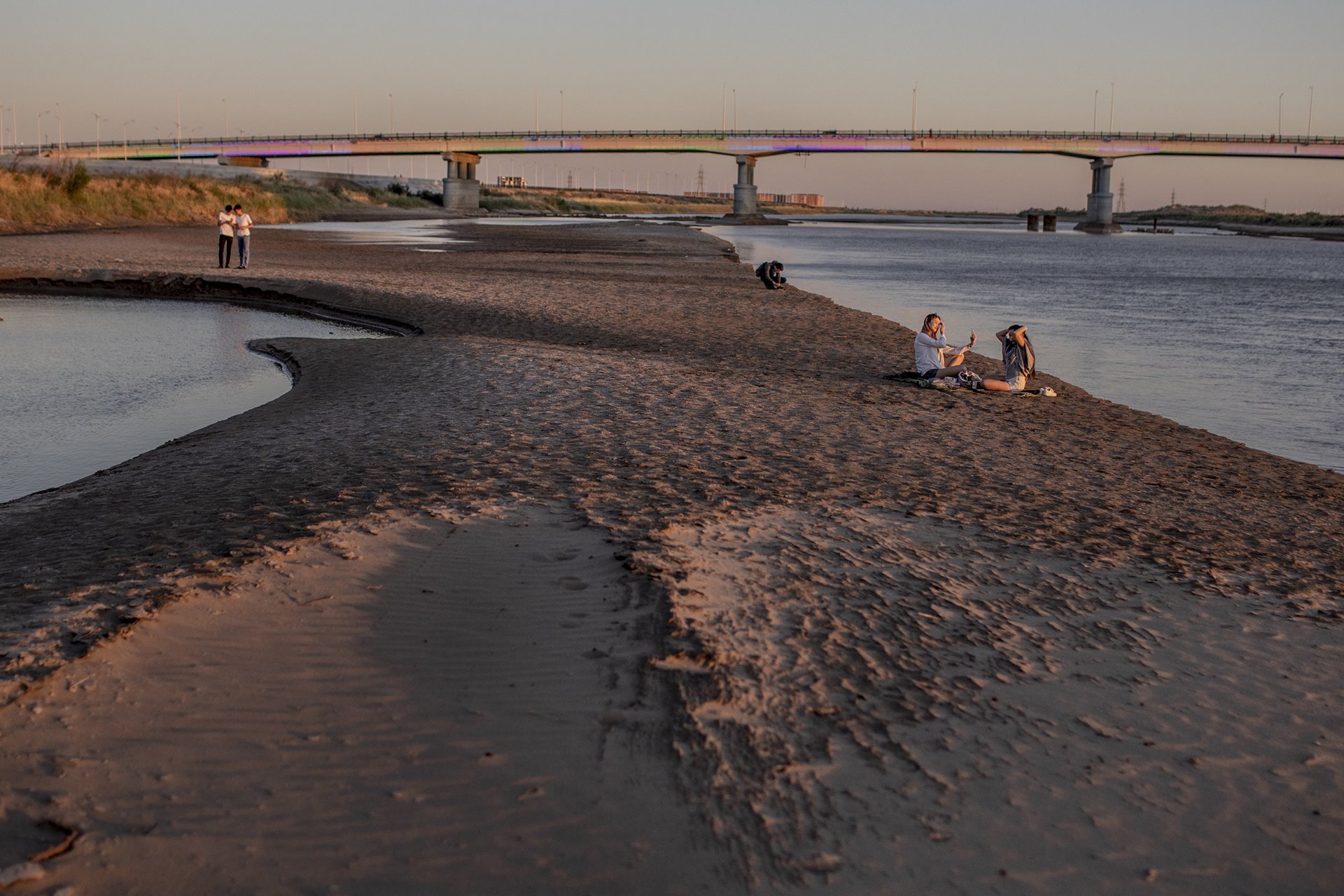 People relax on a sandbank in the Syr Darya River, as it flows through Kyzylorda, in Kazakhstan. The Syr Darya runs shallow in spring, as water is used extensively for agriculture upstream.