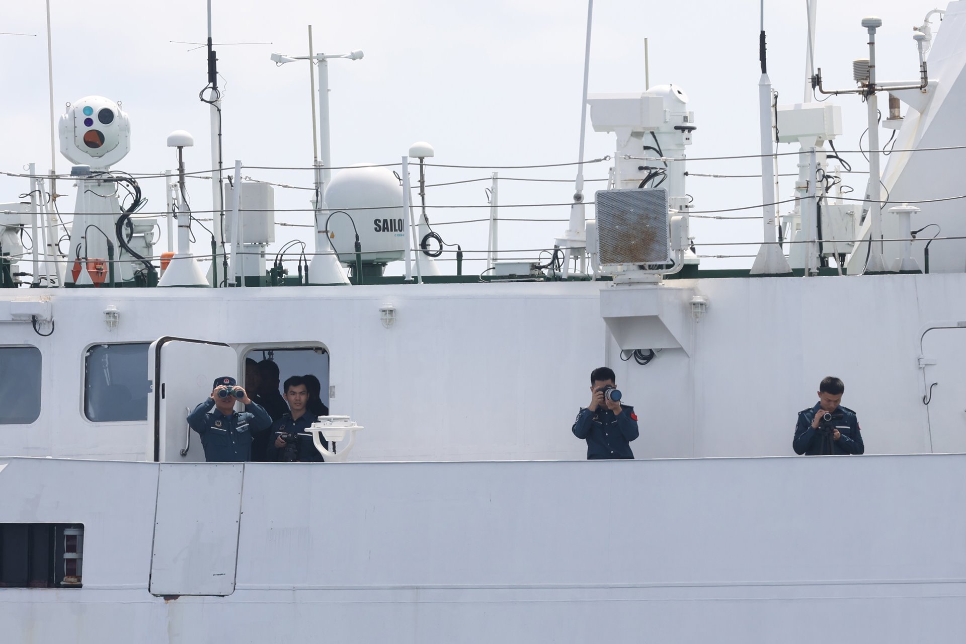Members of the Chinese Coast Guard photograph Filipino fishermen and media observers as they block the fishermen&#39;s attempts to enter the lagoon of Scarborough Shoal, off Zambales province, Philippines. Access to such a situation for journalists with limited means and no military status is difficult.