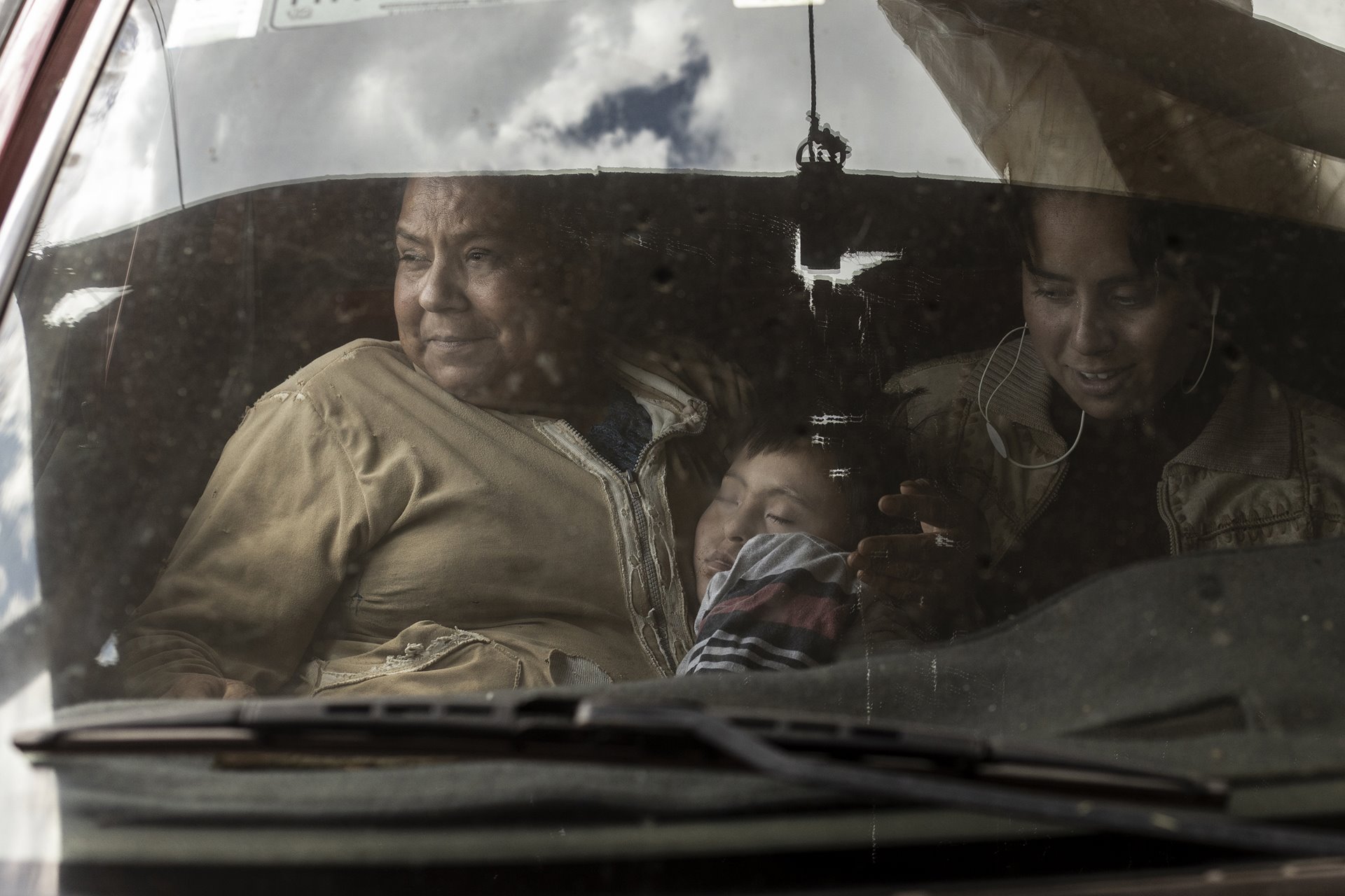 Celerina sits inside the family truck with her children, Gael, who lives with Down syndrome, and Monserrat, after returning from work. Monserrat helps her mother in the fields, but wants to study for a degree and find employment away from the flower industry.