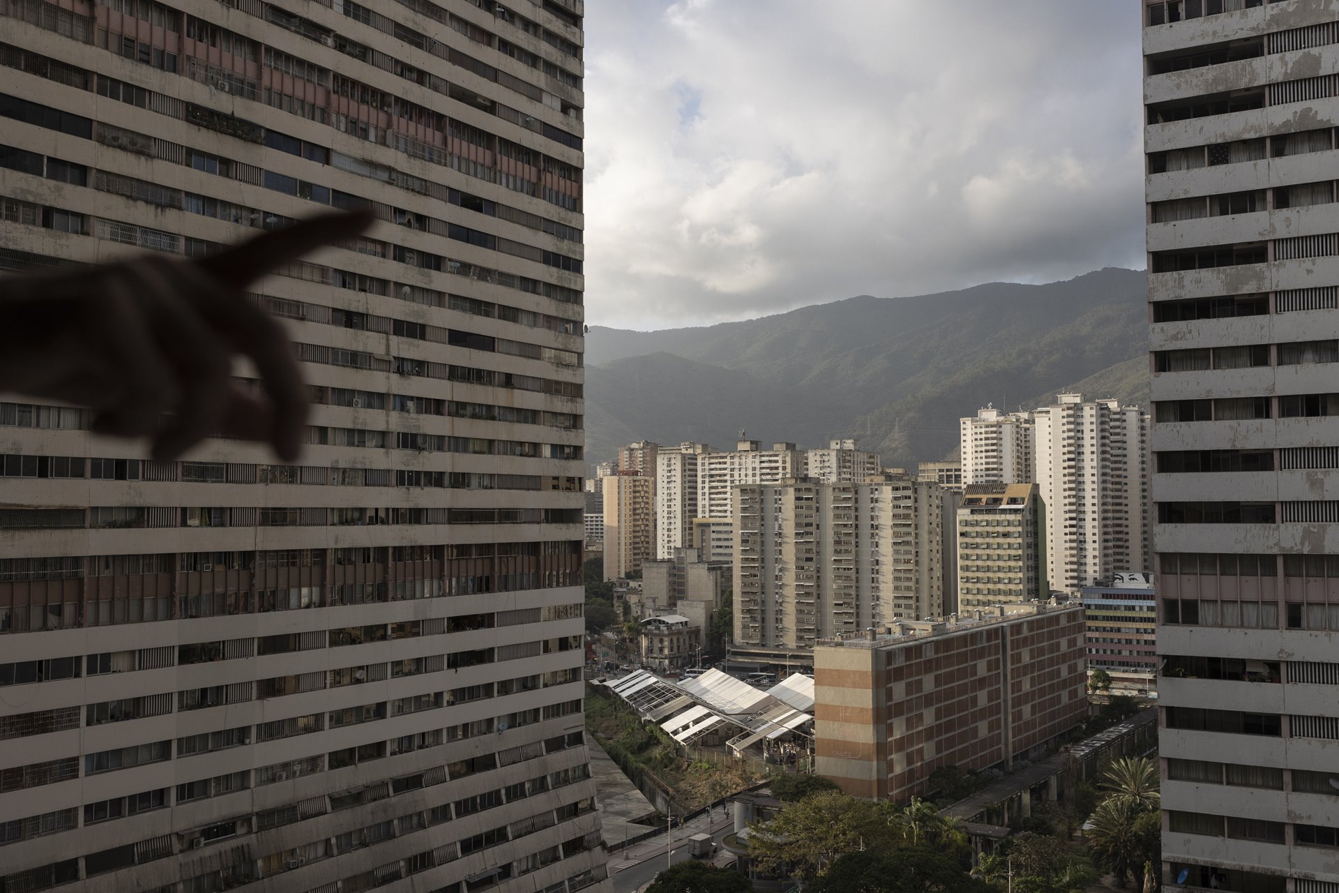 <p>The Twin Towers of Parque Central in Caracas, built in the 1970s, were a prestigious development that until 2003 held the title of tallest skyscrapers in Latin America. Now the buildings leak, are badly maintained, and insecure. In the distance, a mural depicting the eyes of former president, Hugo Chávez, can be seen atop a building.</p>
