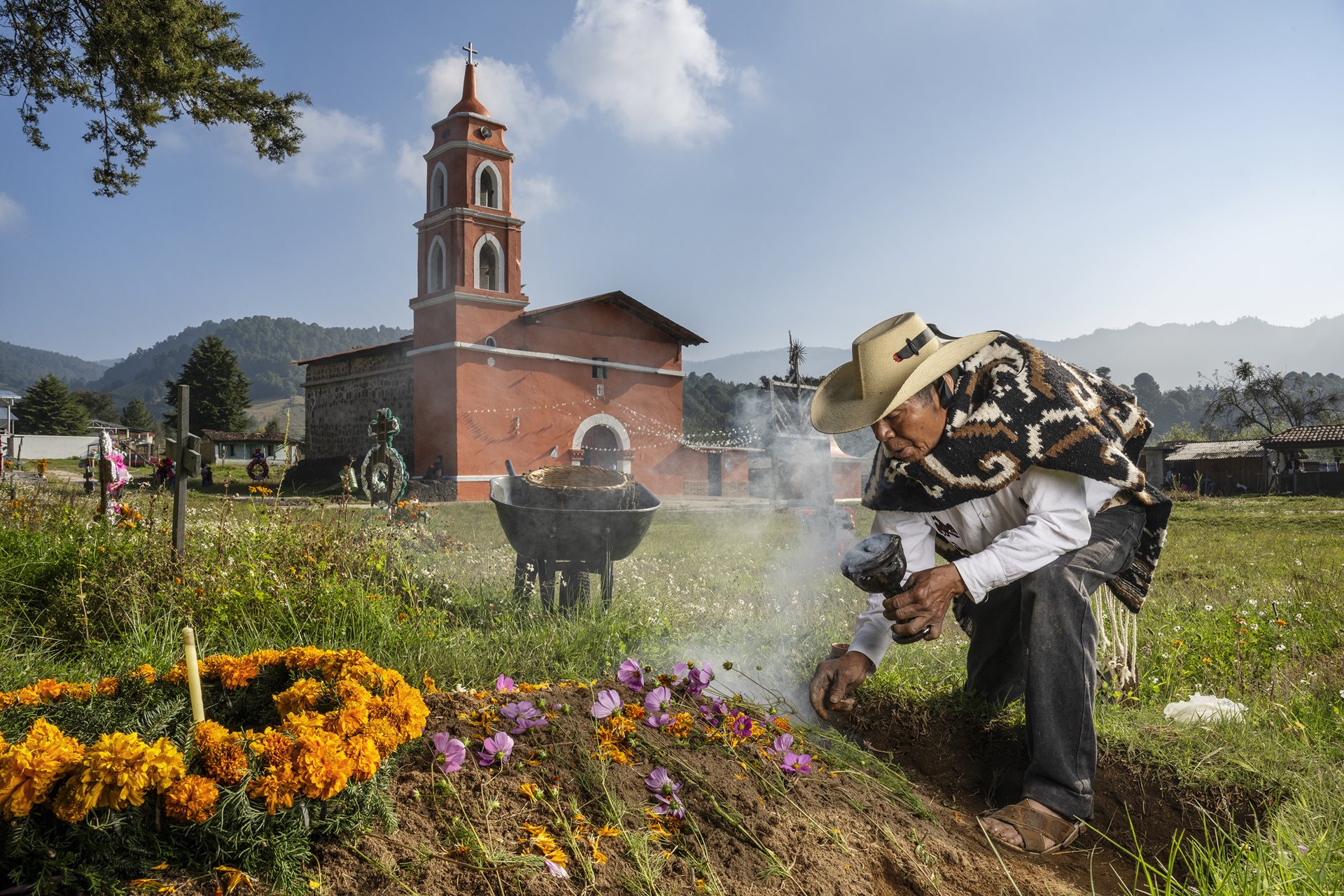 Sabino Marín Reyes decorates the graves of relatives to celebrate Día de los Muertos (the Day of the Dead), in Comunidad Indígena Francisco Serrato, Michoacán, Mexico. Members of the Mazahua Indigenous community believe that the souls of the departed return in the form of monarch butterflies to enjoy the offerings left on graves and altars.&nbsp;