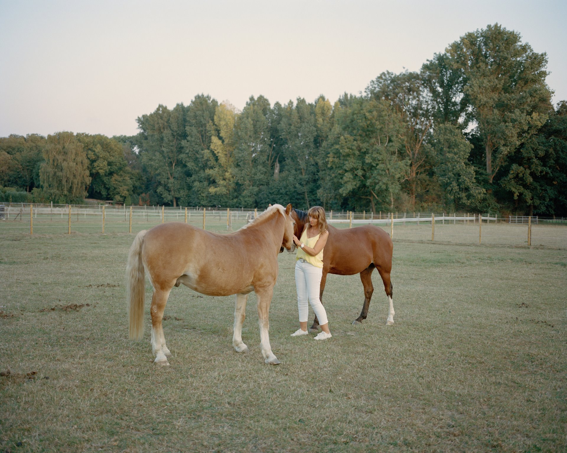 Marita Dresen stands with her horses in her paddock in Kuckum, Germany, where she lives with her parents and children. She is involved in the alliance &quot;Alle Dörfer bleiben&quot; (All villages stay) to preserve the villages threatened by the Garzweiler II open-cast mine.
