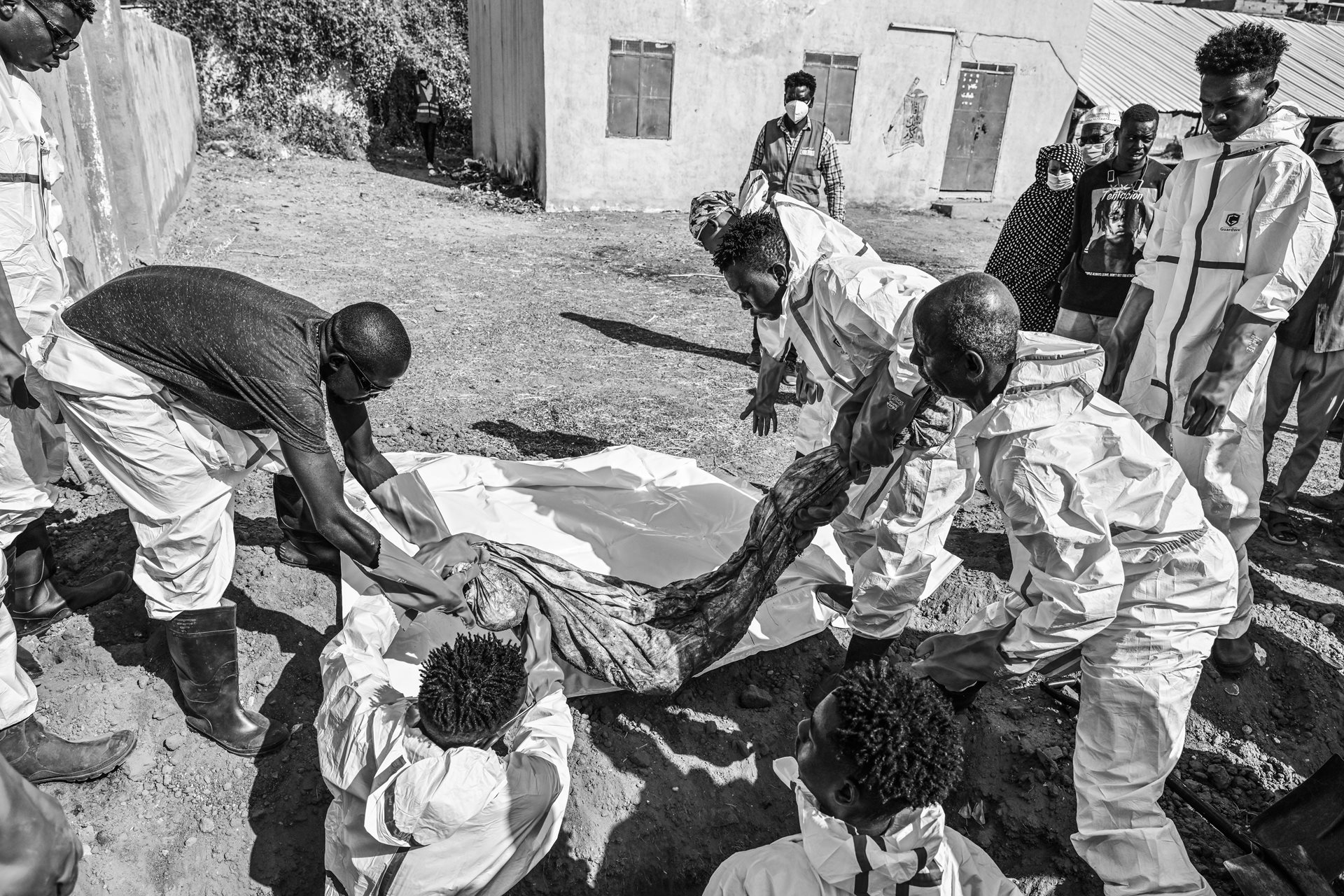 Members of the Red Crescent and other authorities carry a body bag, during the exhumation and transfer of bodies from emergency burial sites in schools to public cemeteries in Khartoum, Sudan.