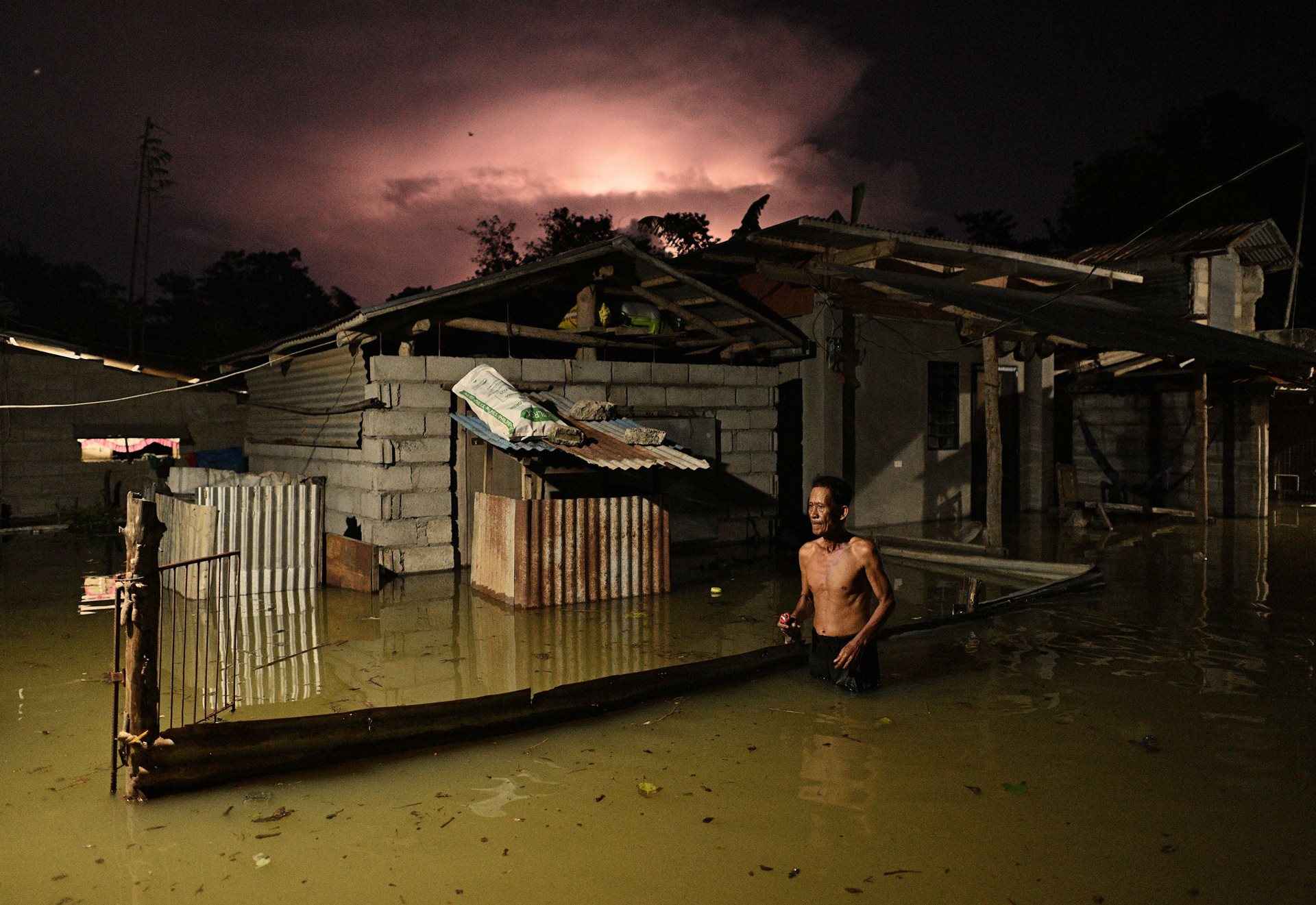 A man wades through a street flooded by heavy rains from Typhoon Toraji, in Ilagan City, Isabela, northern Philippines.