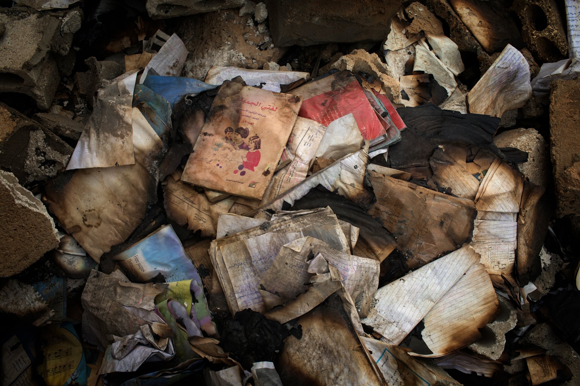 Hundreds of textbooks burned by ISIS extremists inside Hani Hakuf&rsquo;s School in Al-Shaddadi, Syria. At least a quarter of Syrian schools have been damaged or destroyed.