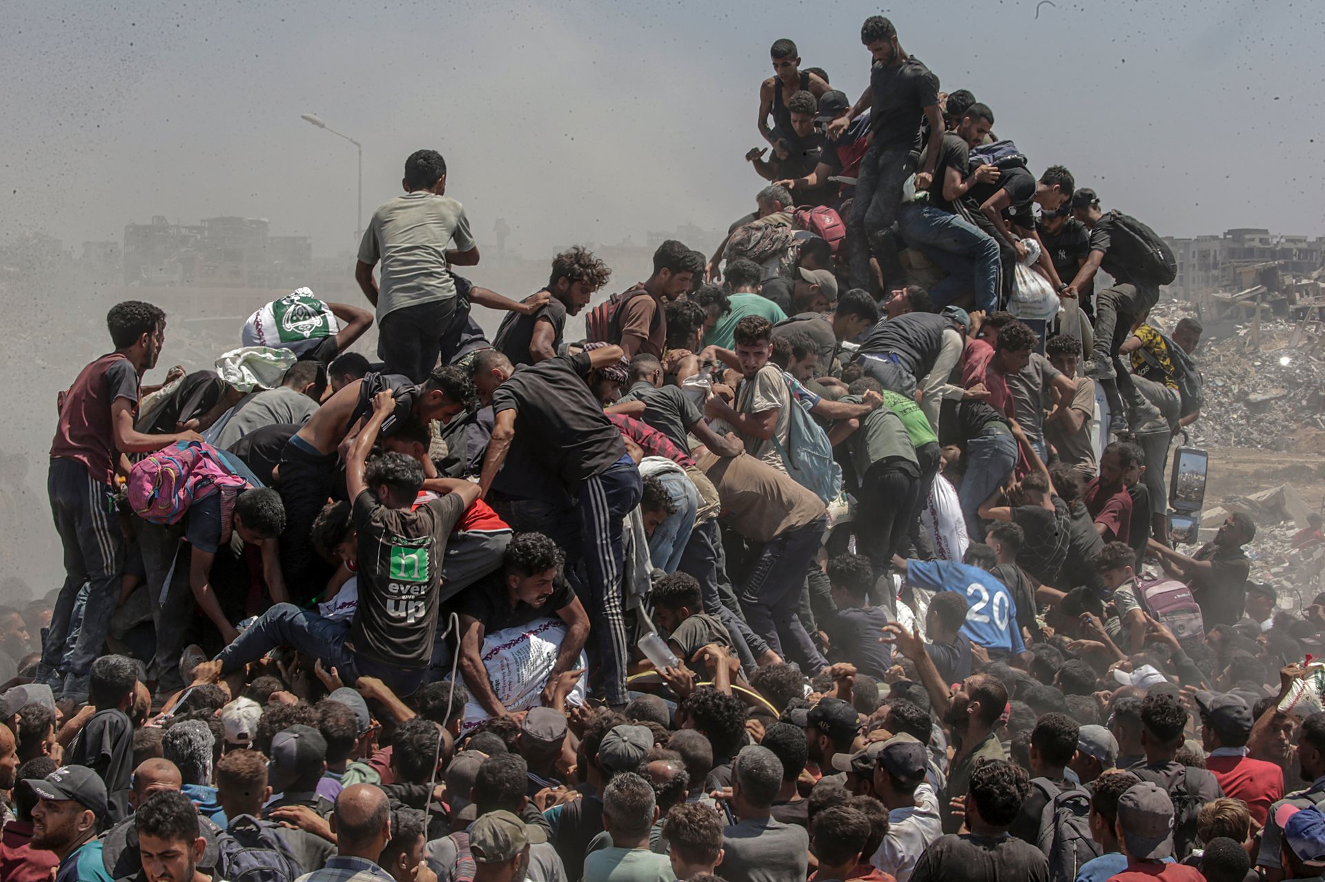 Palestinians climb onto an aid truck as it enters the Gaza Strip via the Zikim Crossing in an attempt to get flour, during what the Israeli military called a &ldquo;tactical suspension&rdquo; in operations to allow humanitarian aid through.