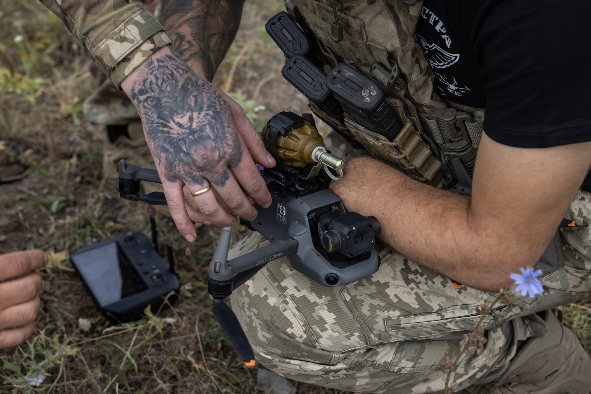 A Ukrainian soldier, known by the call sign &ldquo;Ara,&rdquo; uses his partially amputated arm to steady a drone being fitted with a grenade. Wounded in 2022, he now trains recruits in drone operations. Donetsk region, Ukraine
