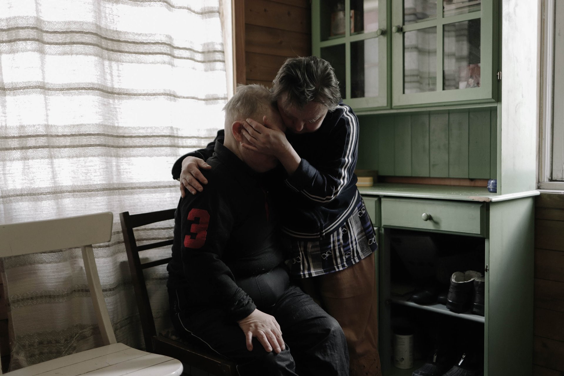 Tatyana consoles Minya in their room as he recalls the death of his mother.