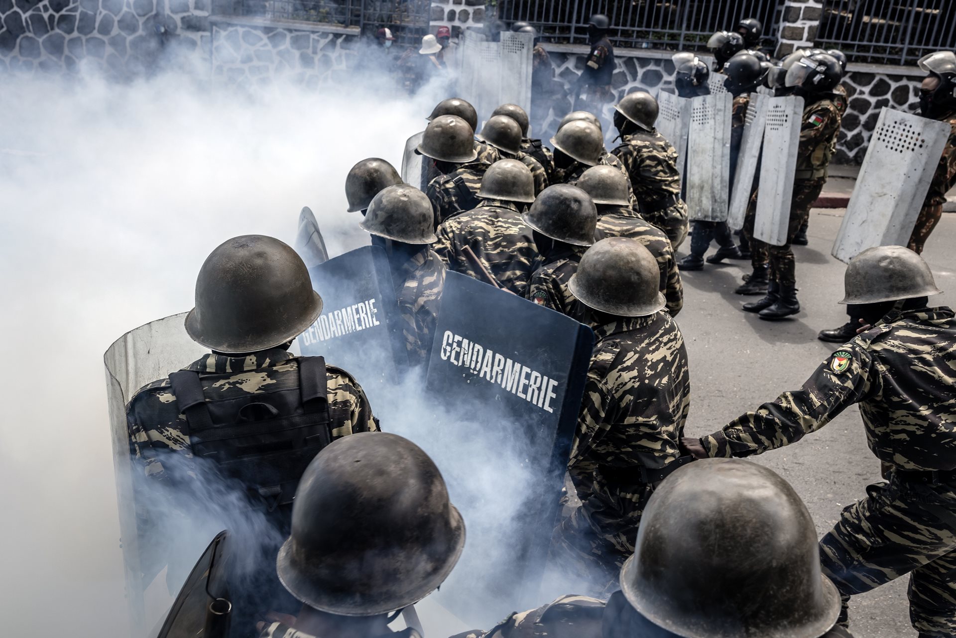 Members of the Malagasy Gendarmerie take cover behind their shields amid tear gas during clashes between demonstrators and security forces in Antananarivo, Madagascar.&nbsp;<br />
&nbsp;