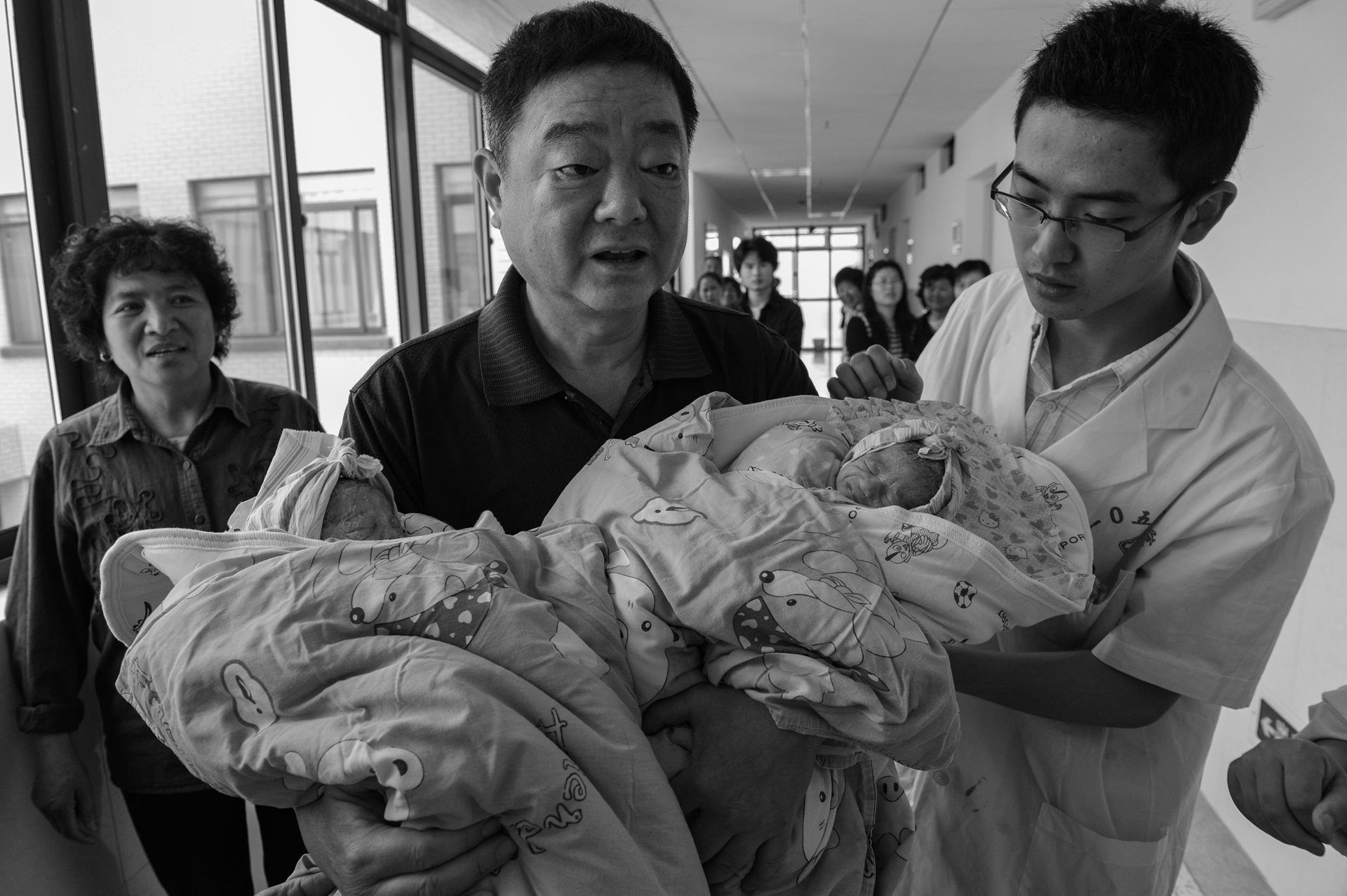 Sheng Hailin&rsquo;s husband, Wu Jingzhou (center), holds their newborn fraternal twins Zhizhi and Huihui, nicknamed Da Shuang (Elder Twin) and Xiao Shuang (Younger Twin). Hefei, Anhui Province, China.
