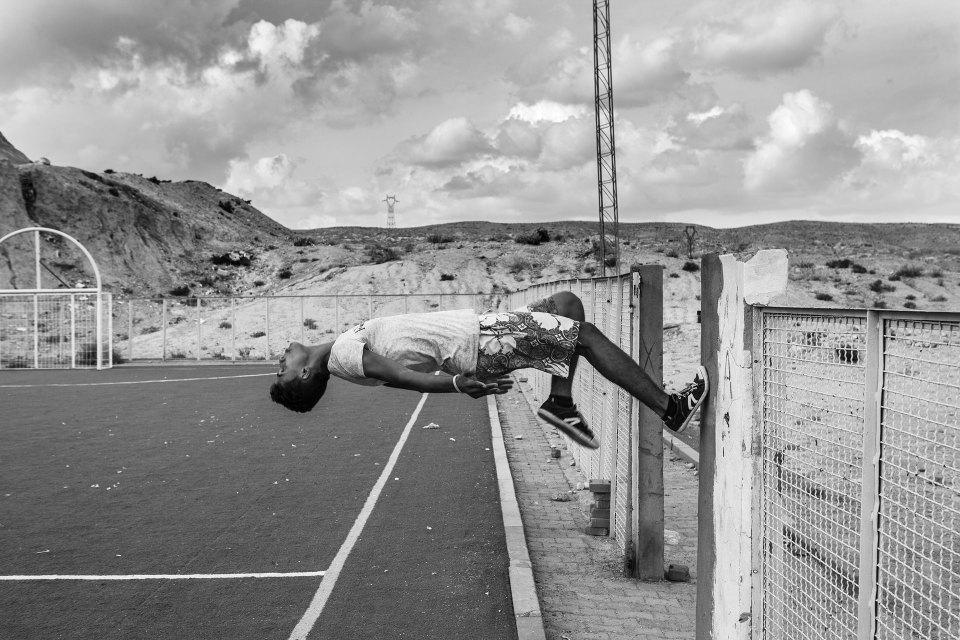 A young man bounces off a fence-post in a soccer field in Umm-Al-Arais, Gafsa, a region crucial to the Tunisian economy for its phosphate mines and marked by high youth unemployment. Earlier in the year jobless young people and miners had staged sit-ins protesting working conditions and unemployment.&nbsp;