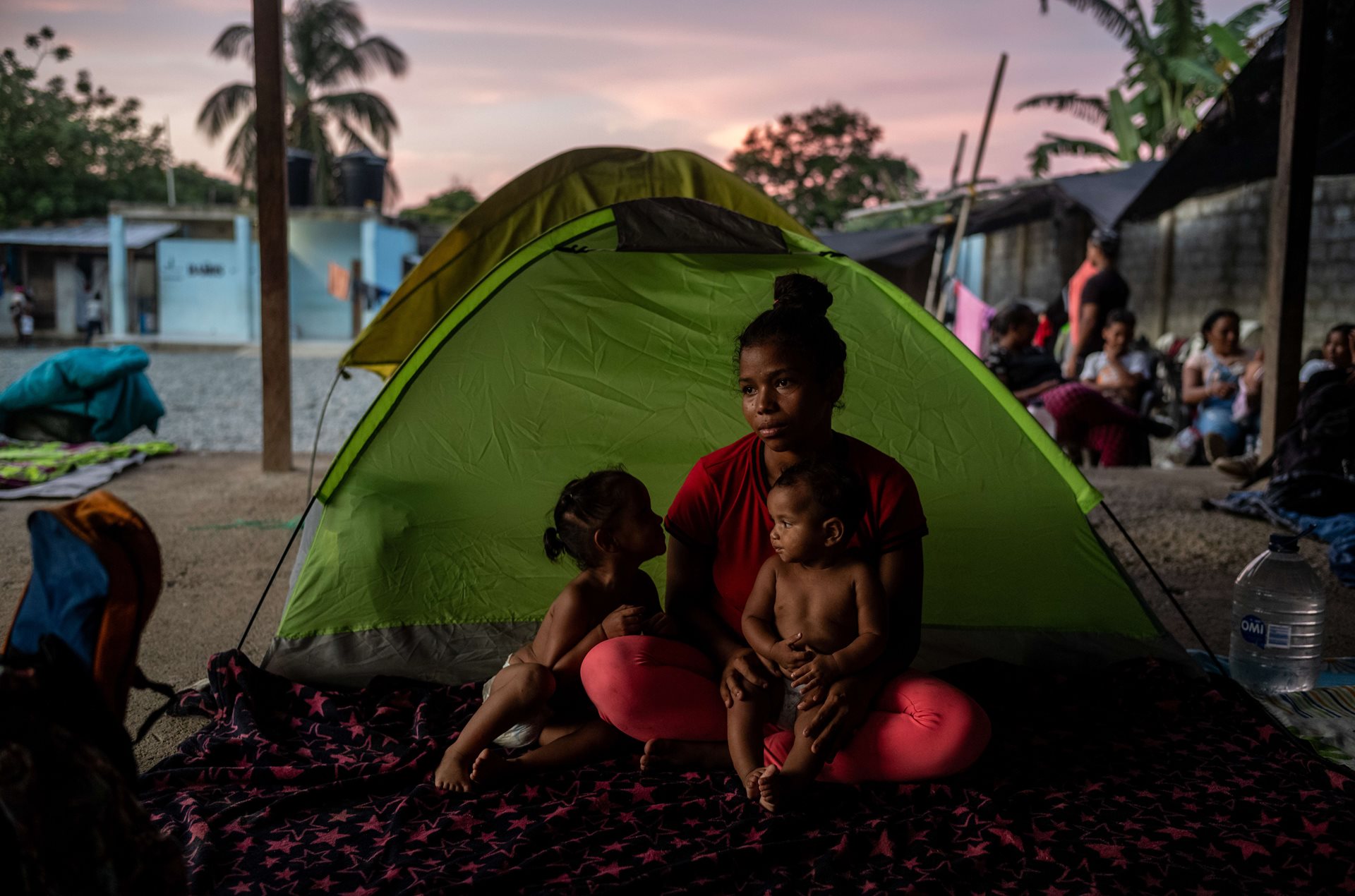 Yineska Andreina Colina (18) sits with her two daughters, Enyerlis Sofia Colina (2) and Eduanyerlis Saray Colina (9 months). By the time they got to Capurganá, Yineska had run out of money and had no idea how she would pay her way through the jungle. Capurganá, Colombia.