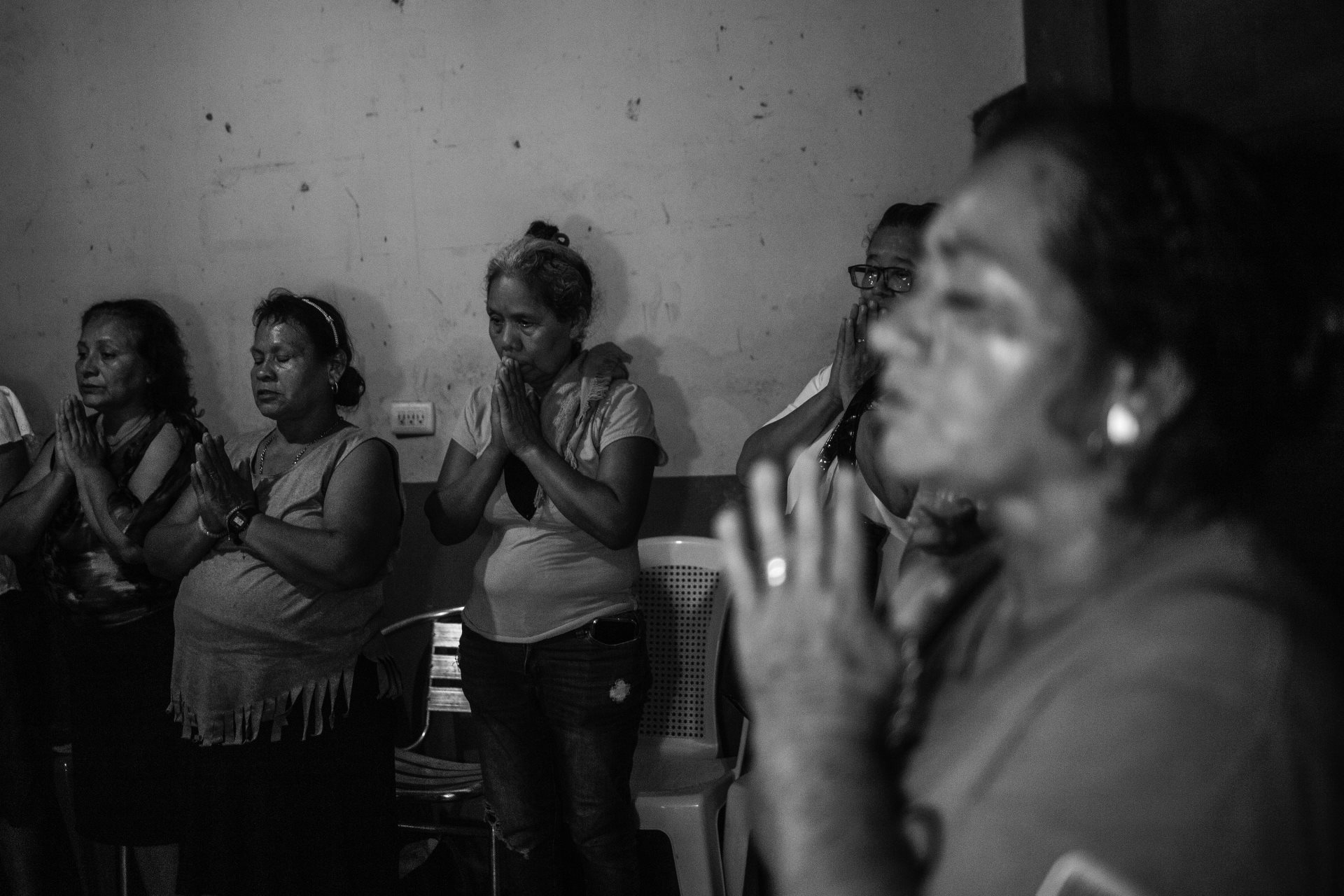 Relatives of Juan Saúl, a 32-year-old worker with no criminal record, pray during a commemoration after his funeral. Juan died in prison after not receiving adequate treatment for his ear cancer. La Libertad, El Salvador.