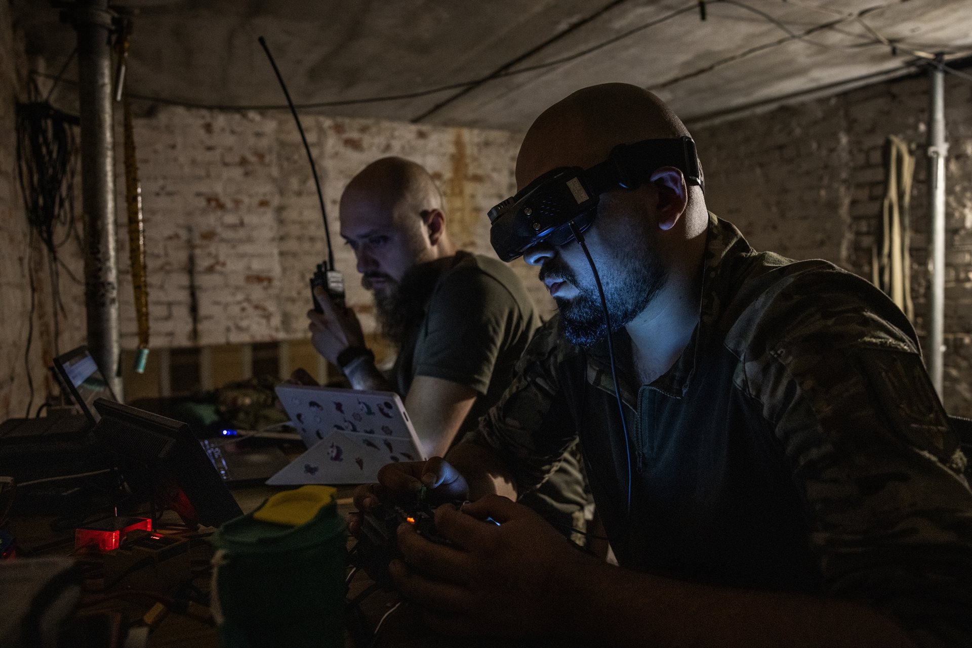 Ukrainian soldiers &ldquo;Prorok,&rdquo; right, and &ldquo;Buryi&rdquo; conduct an FPV drone attack mission on Russian positions from a basement, navigating through live video feeds. Kharkiv region, Ukraine
