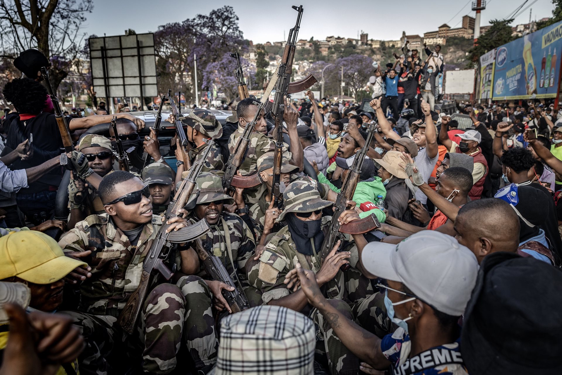 Members of the CAPSAT military unit ride a pickup truck as protesters celebrate their arrival, following clashes between demonstrators and security forces in Antananarivo, Madagascar.&nbsp;