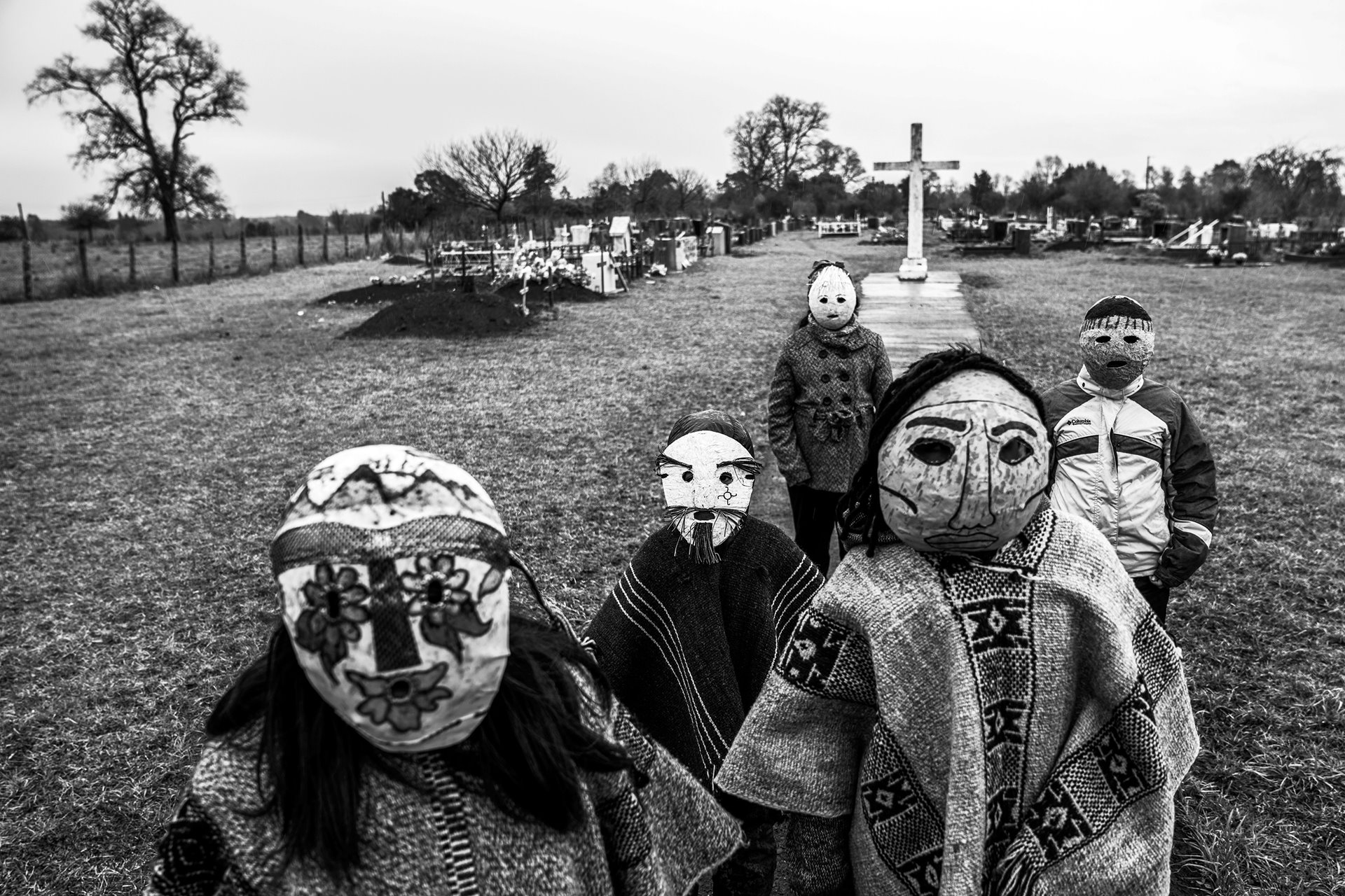 Children wear traditional <em>Ngillatun</em> masks in a Mapuche cemetery, in Maihue, Los Ríos, Chile. The local community successfully opposed building of a hydroelectric dam that would have flooded an adjacent ceremonial site.