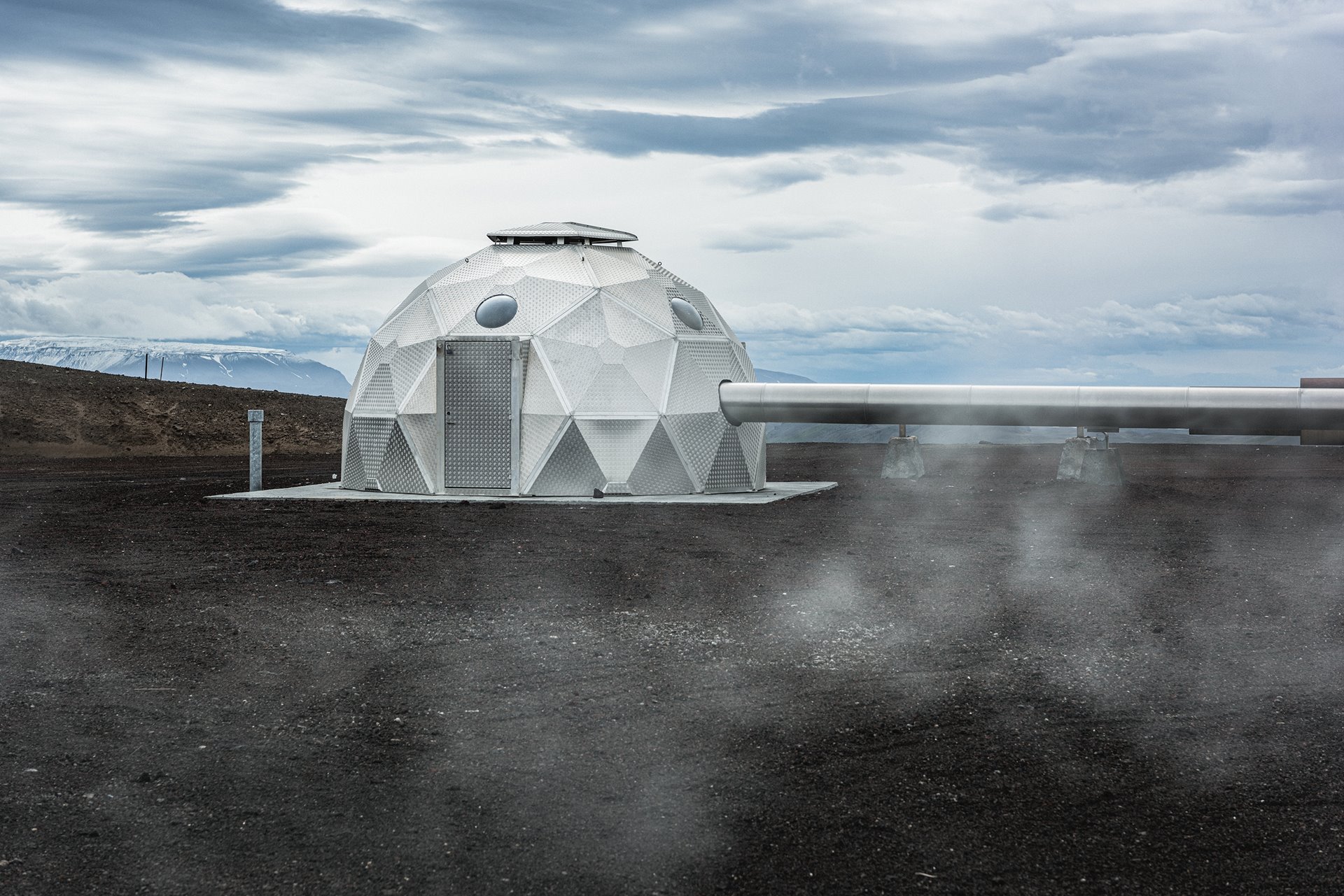 A geodesic dome covers the injection well of a geothermal power plant, in Hellisheiði, Iceland.&nbsp;<br />
<br />
The plant captures geothermal energy from the volcanic Hengill mountain. Geothermal power plants draw fluids from underground reservoirs to the surface to produce steam, which then drives turbines to generate electricity. The process is not emissions-free, as the remaining fluids contain harmful condensates, but the plant injects these back into deep bedrock, where the CO2 can turn rapidly into minerals. The dome covers the borehole and equipment, reducing the visual impact on the environment. By January 2022, this plant had fixed over 100,000 tonnes of CO2 in this way. In cases where carbon emissions cannot be avoided, such carbon fixing can be a valid alternative, although critics say that carbon-capturing technologies detract from the more &nbsp;pressing need to reduce carbon emissions in the first place.&nbsp;