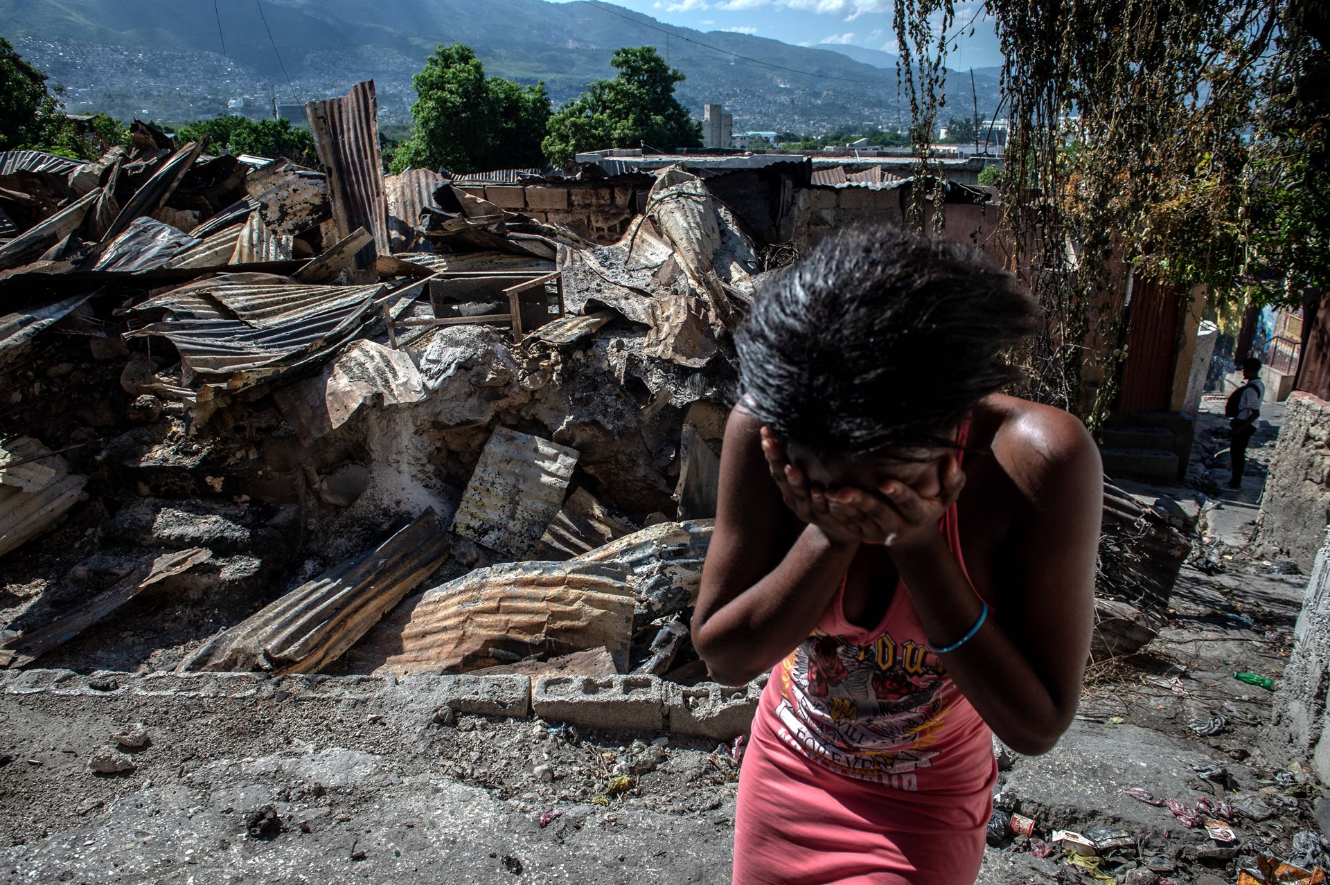 A woman cries outside her house after it was set on fire by armed gangs, in Port Marchand, Port-au-Prince, Haiti.