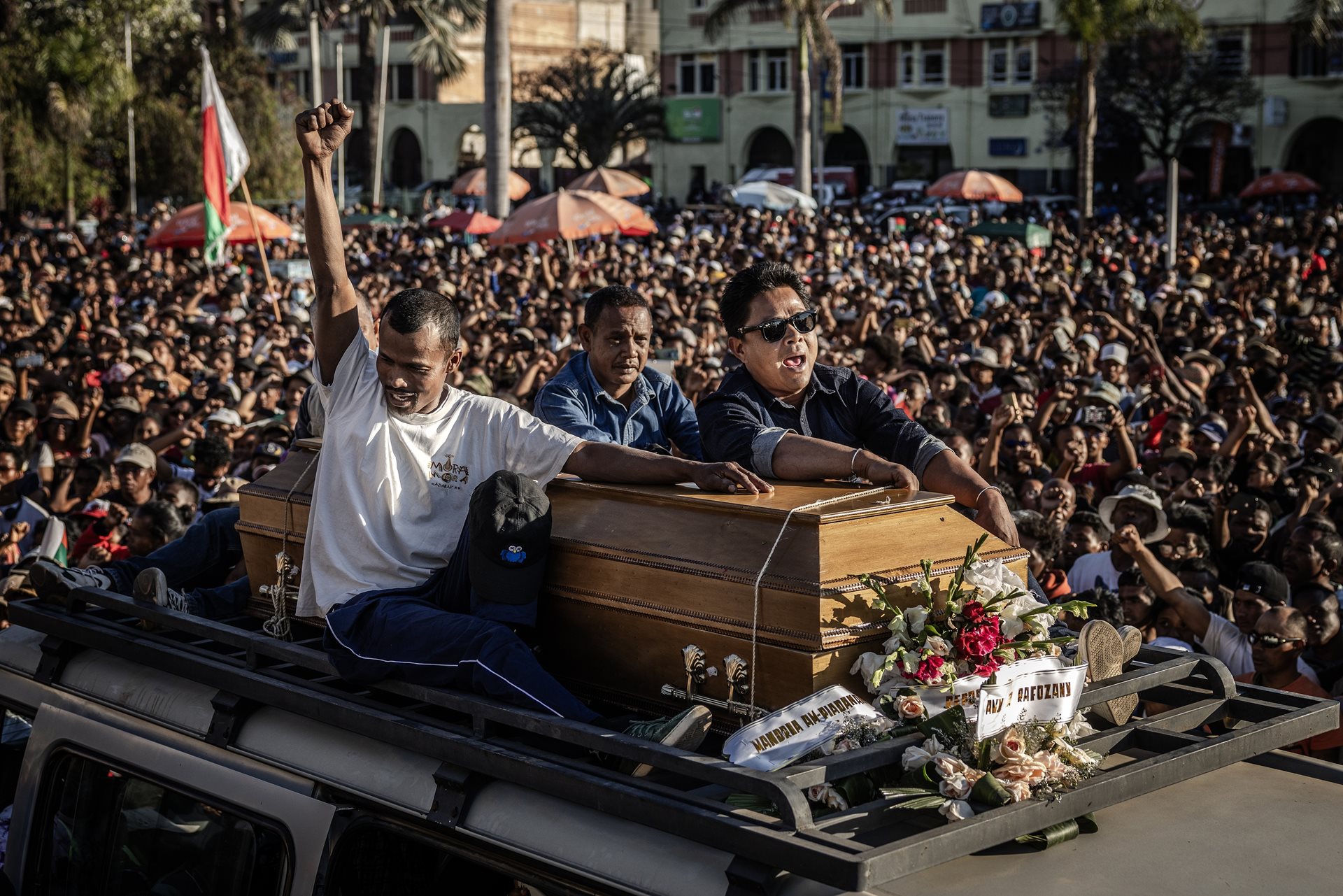 Family members of Safidy Rakotoarisoa, a protester allegedly killed during demonstrations, carry his coffin atop a van and sing the national anthem. Antananarivo, Madagascar.