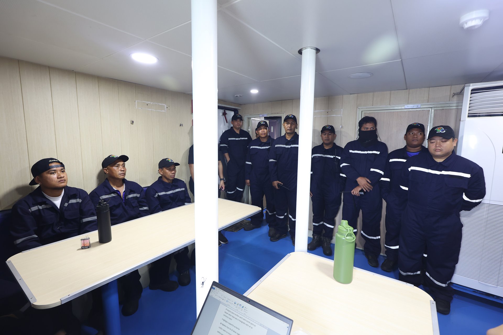 The crew of a Bureau of Fisheries and Aquatic Resources vessel gather for a final briefing in the province of Bataan, Philippines, an hour before heading to deliver supplies of oil and food to Filipino fishermen working near Scarborough Shoal.